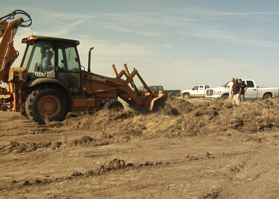 Contractors working with the 28th Civil Engineering Squadron bury spent munitions packed with explosives before detonation on the Air Force Retained Area of the World War II era Badlands Bombing Range Oct. 3, 2011. This controlled explosion will be the last one on this 2,486 acre portion of the Badlands Bombing Range (U.S. Air Force photo by Amn Kate Walker/Released).