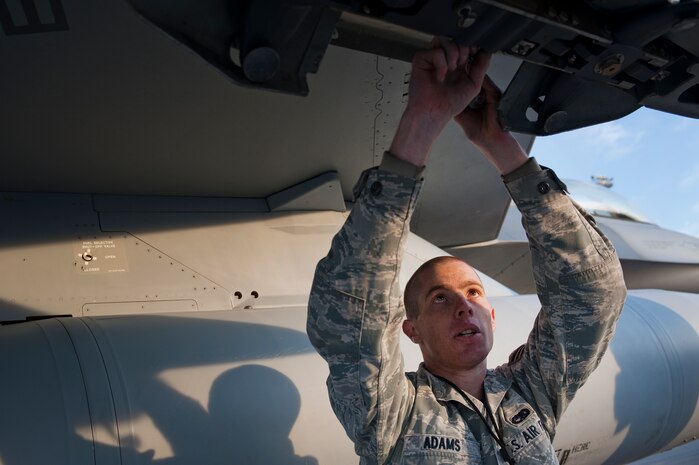 U.S. Air Force Senior Airman Robert Adams, 57th Aircraft Maintenance Squadron aircraft armament systems journeyman, prepares an F-16 Fighting Falcon to be armed during the quarterly weapons load competition Oct. 7, 2011, at Nellis Air Force Base, Nev. Weapons load competitions are conducted quarterly to keep Airmen sharp and recognize superior performers. Weapons load teams are evaluated for use of the checklist, safety, and overall speed. (U.S. Air Force photo by Staff Sgt. Christopher Hubenthal/Released)