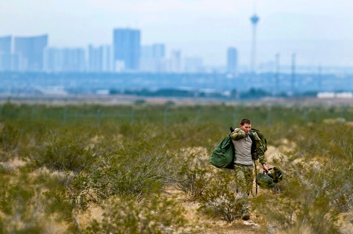 U.S. Air Force Staff Sgt. Matthew Greer, 414th Combat Training Squadron survival evasion resistance escape specialist, hikes back to the drop zone after a training mission Oct. 4, 2011, at Nellis Air Force Base, Nev. RED HORSE and 414 CTS Airmen perform airdrop missions to stay current on training and certifications, enabling them to perform jump missions and operate their own drop zones. (U.S. Air Force photo by Senior Airman Brett Clashman/Released) 