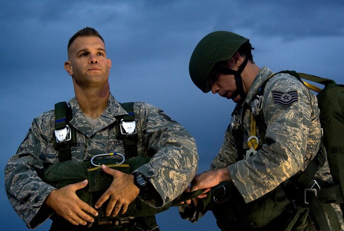 From left, U.S. Air Force Master Sgt. Guenther Bogensperger, 820th RED HORSE Airborne flight airborne water and fuels systems maintenance superintendent, receives  a Jumpmaster Pre-inspection from Tech Sgt. James Spreter, 6th Combat Training Squadron joint terminal attack controller instructor, prepare to board a C-130 Hercules during a jump mission Oct. 4, 2011, at Nellis Air force Base, Nev. RED HORSE and 6 CTS Airmen perform airdrop mission to stay current on training and certifications, enabling them to perform jump missions and operate their own drop zones. (U.S. Air Force photo by Staff Sgt. Christopher Hubenthal/Released)