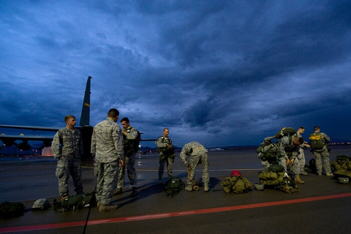 U.S. Air Force Airmen, 820th RED HORSE Airborne flight and 6th Combat Training Squadron, prepare their gear prior to a C-130 Hercules jump mission Oct. 4, 2011, at Nellis Air Force Base, Nev. RED HORSE and 6 CTS Airmen perform airdrop mission to stay current on training and certifications, enabling them to perform jump missions and operate their own drop zones. (U.S. Air Force photo by Staff Sgt. Christopher Hubenthal/Released)