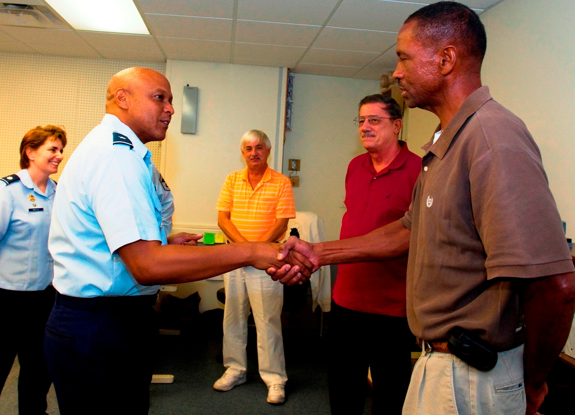 PATRICK AIR FORCE BASE, Fla. -- Brig. Gen. Anthony Cotton, 45th Space Wing commander, coins Tim McCall, 45th Space Communications Squadron, while, from left, Lt Col. Pamela Woolley, 45 SCS commander, and co-workers Mike Knight and Joe Joscak look on. General Cotton presented commander's coins to Joscak and McCall for saving Knight's life, Joscak, 45 SCS Chief of Client Services, dispatched McCall to Knight's apartment after he failed to report to work and didn't respond to phone calls Aug. 15. Knowing Knight has Type 1 diabetes, they persuaded an apartment manager to open his door, and McCall found Knight in a diabetic coma, before calling emergency responders.