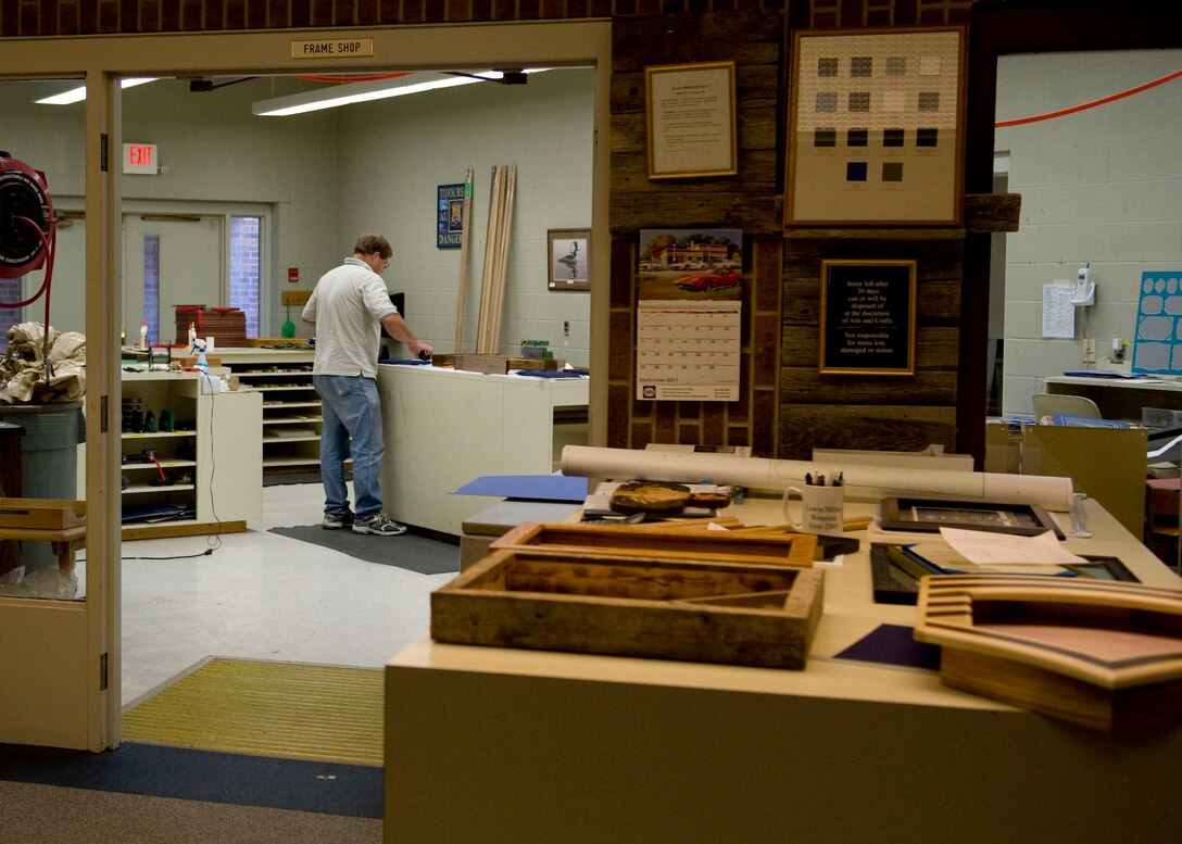 John Berry, 28th Force Support Squadron Arts and Crafts recreation assistant, works on current projects at the frame shop of the Arts and Crafts Center on Ellsworth Air Force Base, S.D., Oct. 4, 2011. The Arts and Crafts Center provides a variety of products, such as shadow boxes, personalized awards, and engraved plaques. (U.S. Air Force photo by Airman 1st Class Kate Thornton/Released)