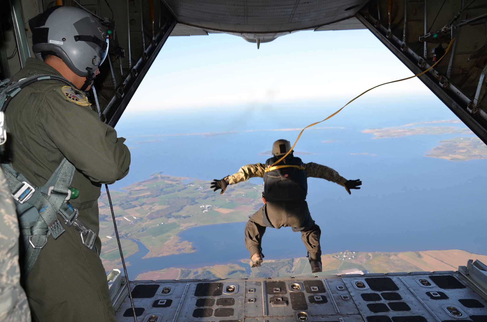 SUMMERSIDE, PRINCE EDWARD ISLAND, Canada - Pararescueman Master Sgt. Richard Oberstar, 304th Rescuq Squadron, Portland, Ore., performs a static-line jump out of a WC-130J Hercules aircraft here. PJs and Canadian Search and Rescue Technicians performed ongoing sky dives from exercise aircraft onto both open and confined drop zones (DZ) from heights ranging from 3,000 to 12,500 ft. (U.S. Air Force photo/Airman 1st Class Natasha Dowridge)