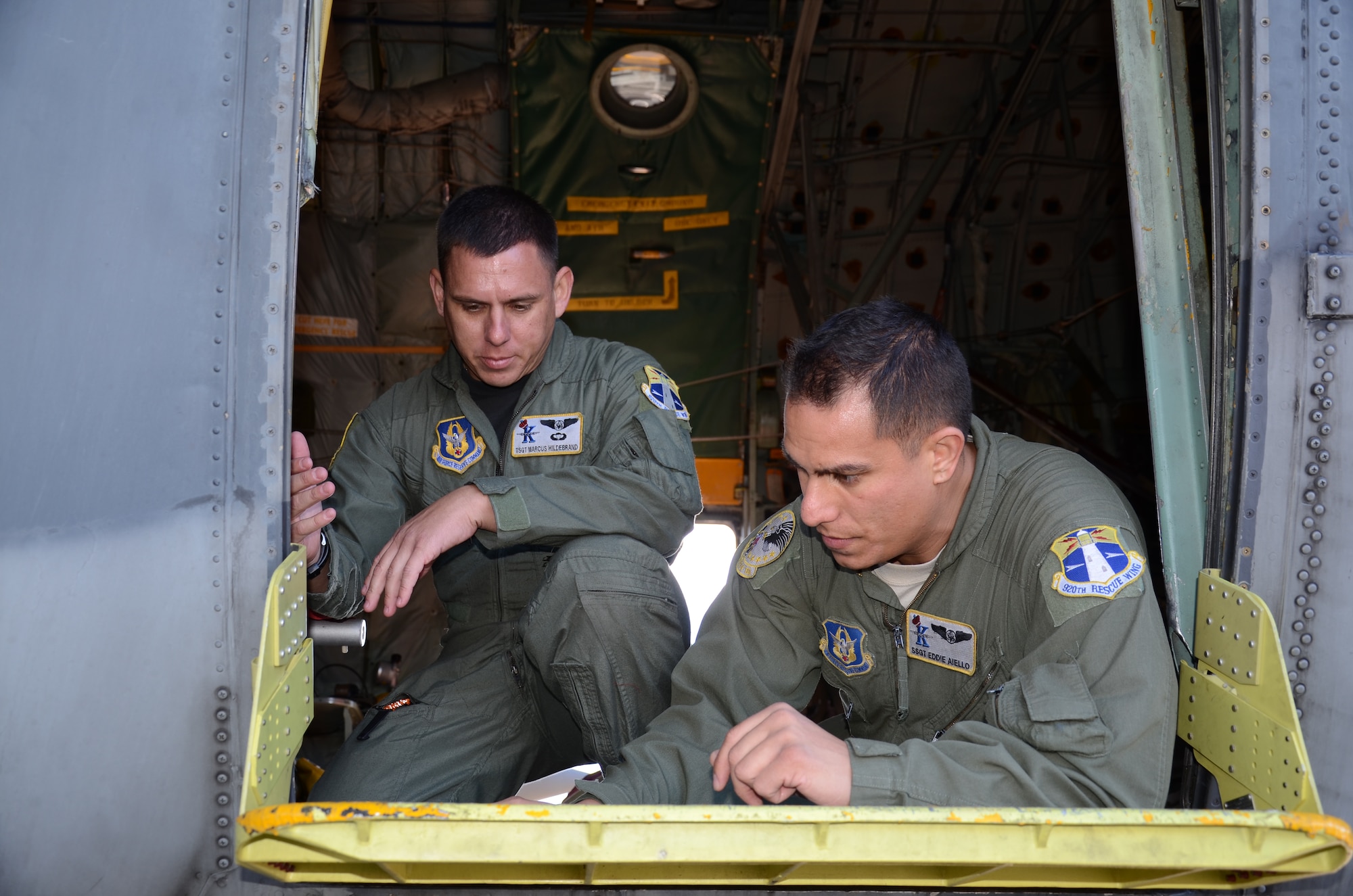 SUMMERSIDE, PRINCE EDWARD ISLAND, Canada - Loadmasters Staff Sgt. Edward Aiello and Tech. Sgt. Marcus Hildebrand, inspect the side paratroop door prior to free fall and para-bundle exercises from the C-130's ramp during a U.S. and Canada Search and Rescue Exercise Sept. 25 - Oct. 1. The training is used as a tool to hone accuracy in dropping packages of additional survival supplies or equipment from heights of 150-300 feet off the ground. (U.S. Air Force photo/Airman 1st Class Natasha Dowridge)