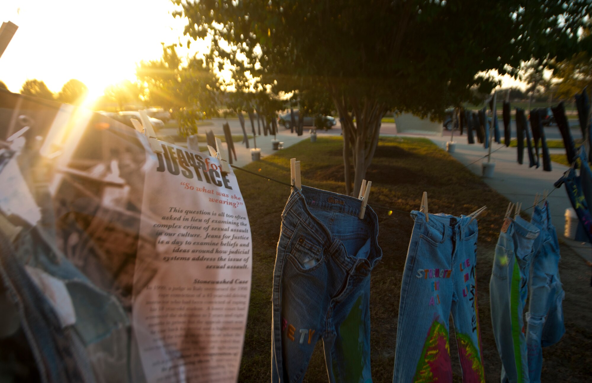 A poster with the words “Jeans for Justice” hangs on a clothes line during a 5K event to raise awareness about sexual assault at Moody Air Force Base, Ga., Oct. 7, 2011. The name Jeans for Justice was inspired by a 1999 Italian court case that determined it was not possible for the victim to have been sexually assaulted because she was wearing jeans. (U.S. Air photo by Airman 1st Class Joshua Green/Released) 
         
    
