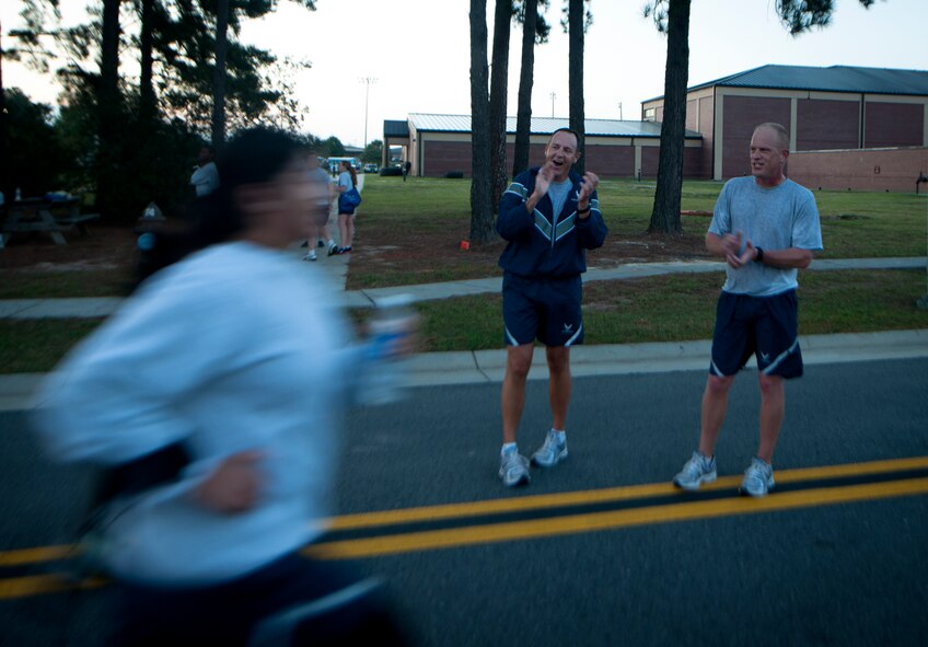 U.S. Air Force Col. Christopher Short, 23rd Wing vice commander, and Chief Master Sgt. Frank Batten,  23rd WG command chief, cheer on an Airman towards the end of the finish line during a 5K run in recognition of October’s observances at Moody Air Force Base, Ga., Oct. 7, 2011. Topics observed this month are National Domestic Violence, National Autism , Breast Cancer Awareness, Sudden Infant Death Syndrome, Suicide Prevention Week and Red Ribbon Week. (U.S. Air photo by Airman 1st Class Joshua Green/Released)             
    
