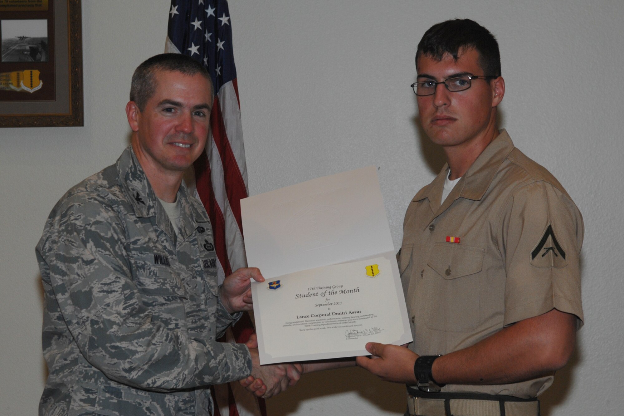 GOODFELLOW AIR FORCE BASE, Texas -- Col. JD Willis, 17th Training Group Commander, presents Marine Lance Cpl. Dmitri Assur with the 316th Training Squadron Student of the Month award for September, Oct. 7. (U.S. Air Force photo/Staff Sgt. Laura R. McFarlane)