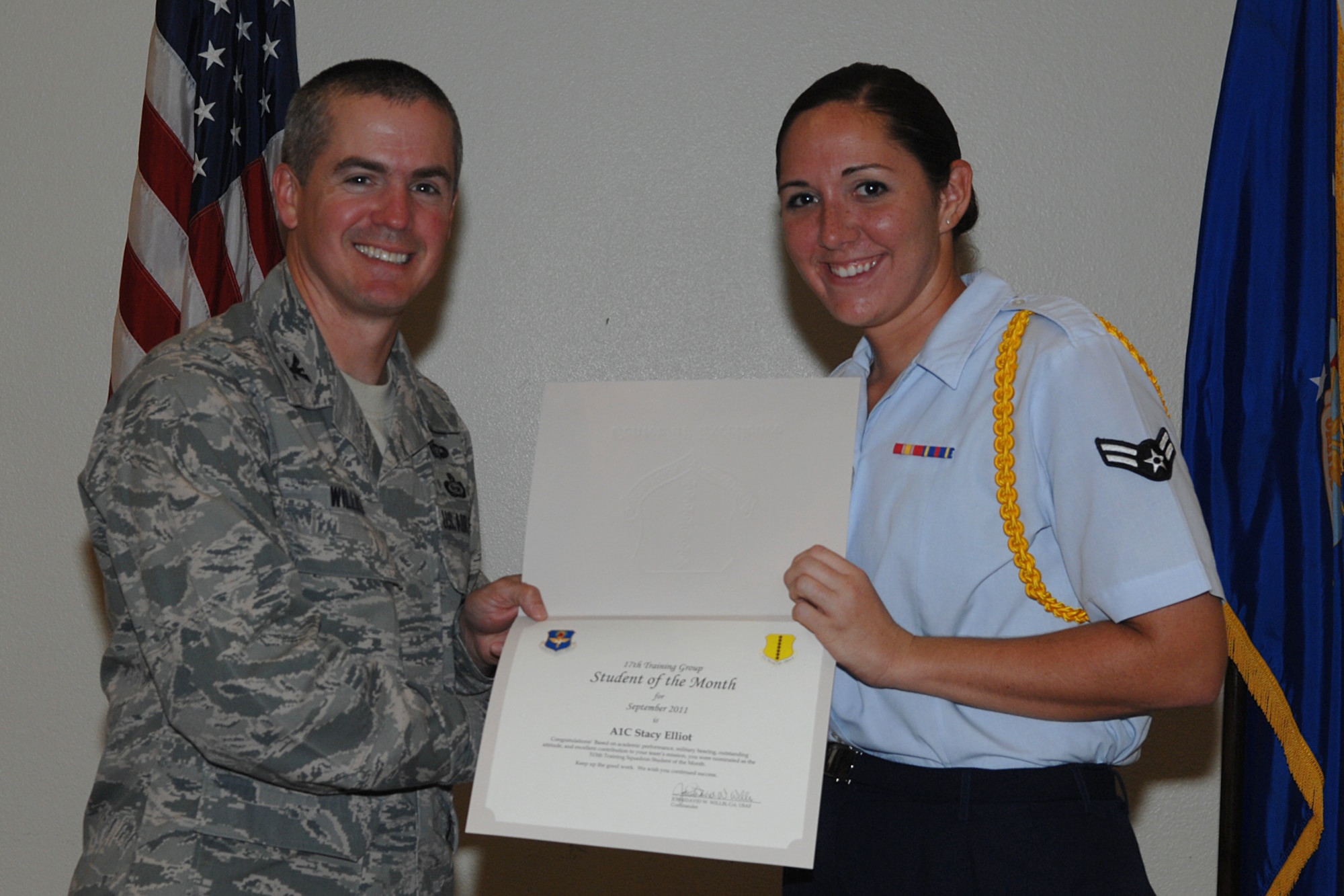GOODFELLOW AIR FORCE BASE, Texas -- Col. JD Willis, 17th Training Group Commander, presents Airman 1st Class Stacy Elliot with the 315th Training Squadron Enlisted Student of the Month award for September, Oct. 7. (U.S. Air Force photo/Staff Sgt. Laura R. McFarlane)