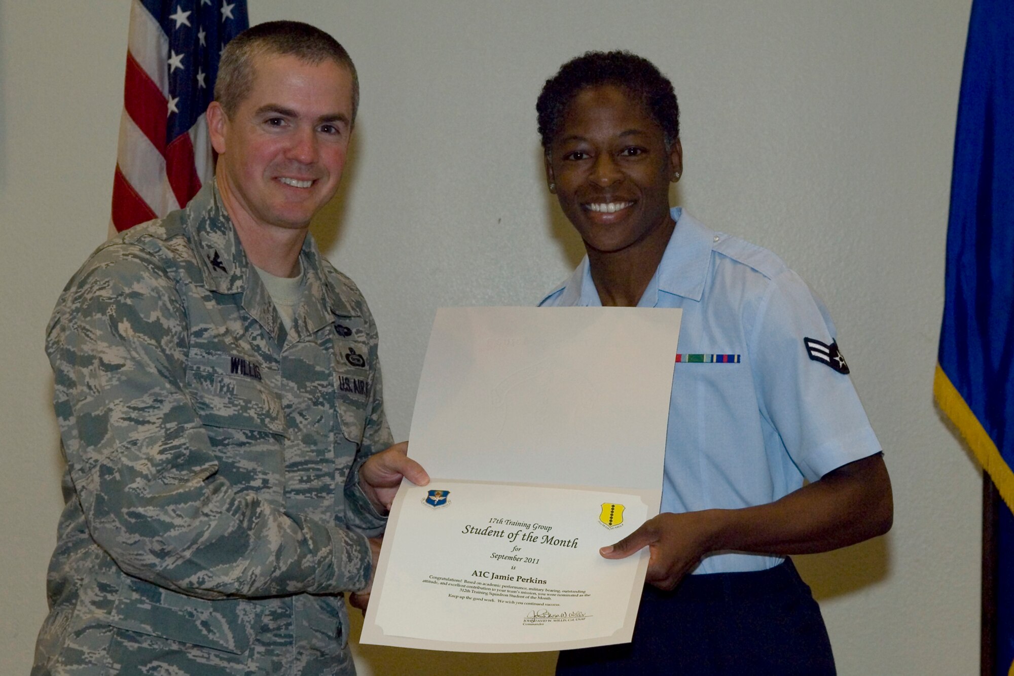 GOODFELLOW AIR FORCE BASE, Texas -- Col. JD Willis, 17th Training Group Commander, presents Airman 1st Class Jamie Perkins with the 312th Training Squadron Student of the Month award for September, Oct. 7. (U.S. Air Force photo/Staff Sgt. Laura R. McFarlane)