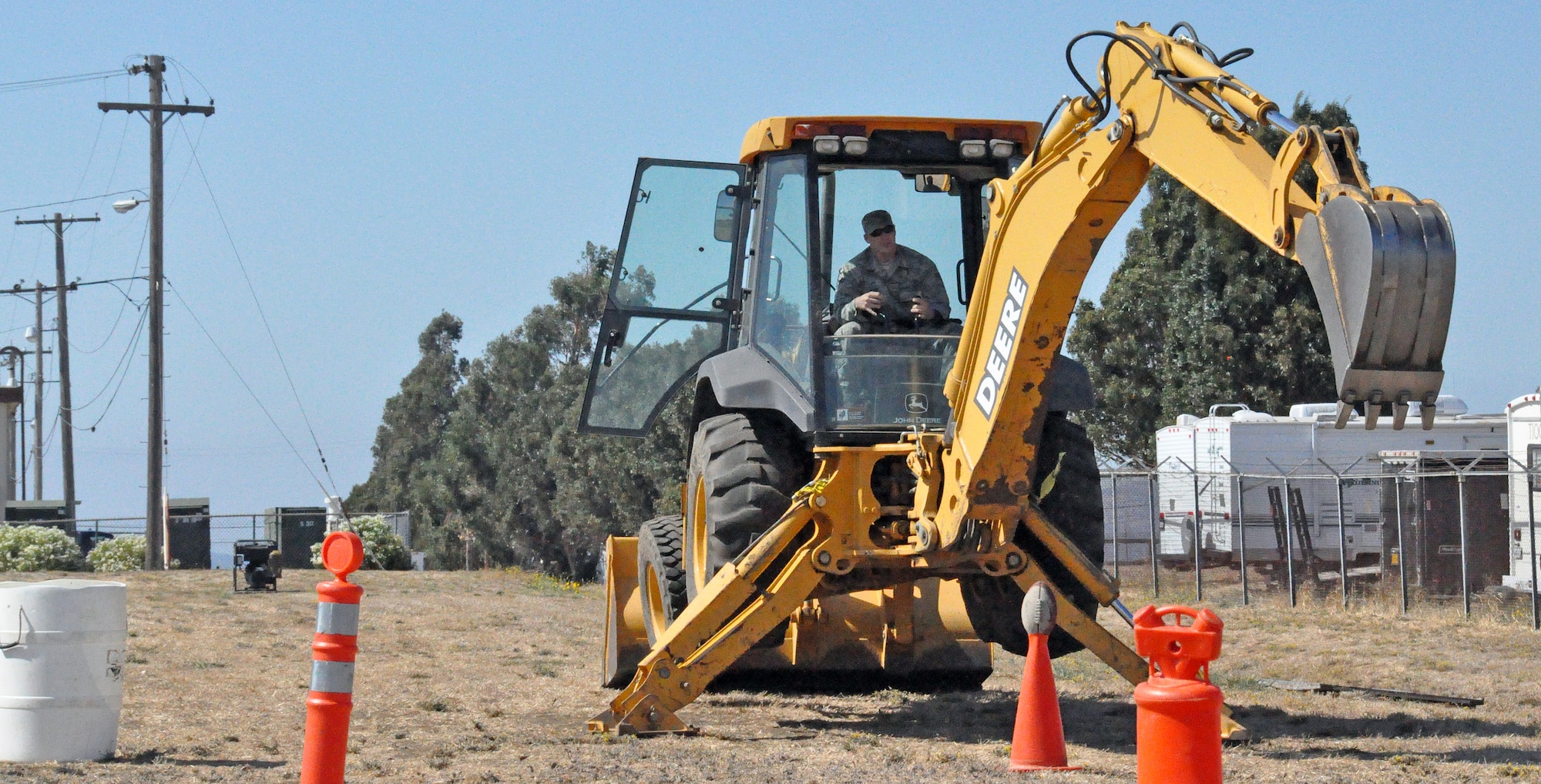 Airman 1st Class Craig Runk from alpha flight demonstrates percision and accuracy on the backhoe by picking up a football with the crane and dumping it in a bucket Sept. 27 during the rodeo competition portion of the wartime skills week for the 60th Civil Engineering Squadron. (U.S. Air Force photo/ Airman Madelyn Ottem)