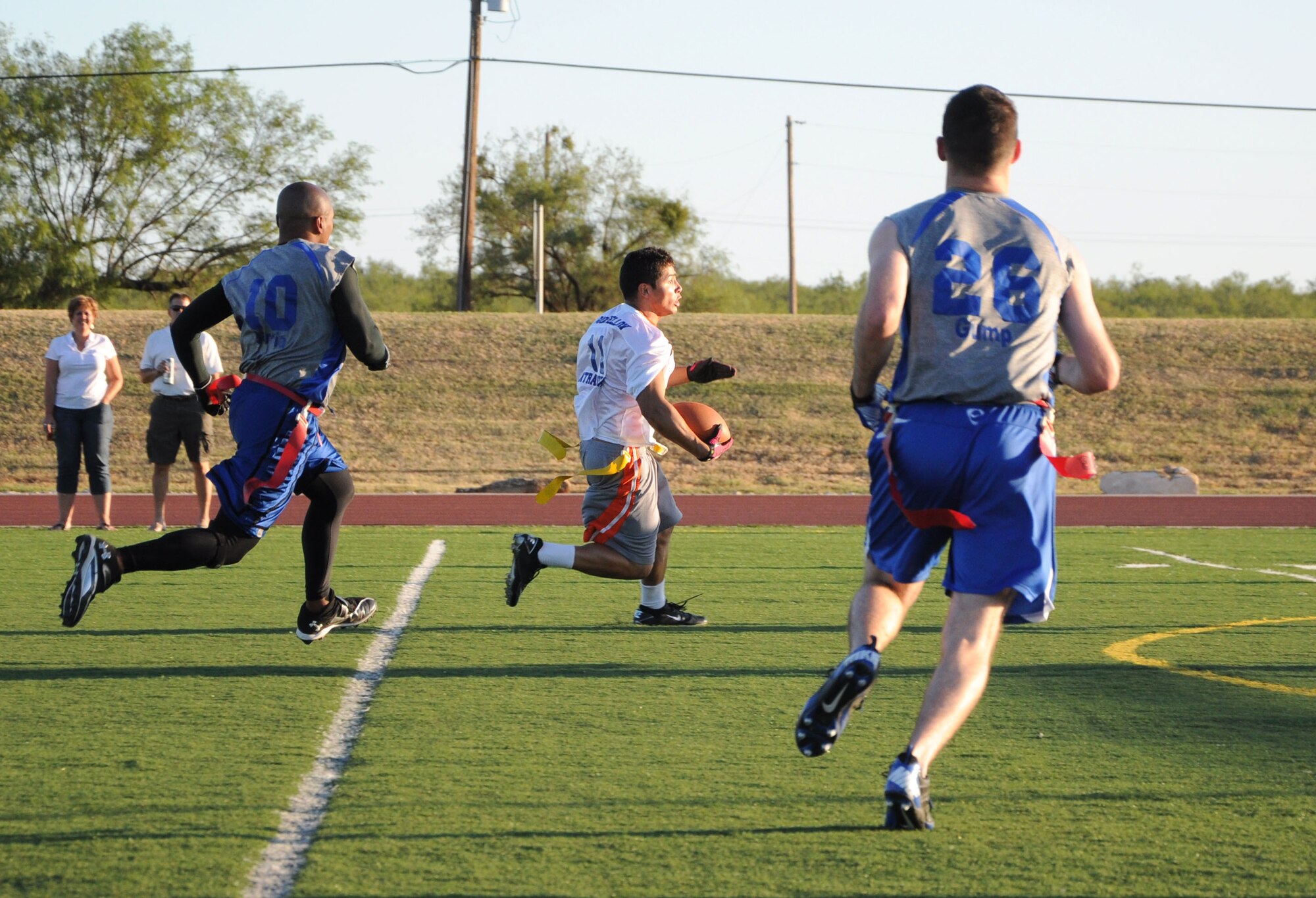 GOODFELLOW AIR FORCE BASE, Texas--  Anthony Castillo from the 17th Force Support Squadron and member of the Mission Support Group’s flag football team, the Junkyard Dawgs, heads down the sideline while dodging defenders of the from the 316th Training Squadron Sharks Oct. 6 at Mathis Field. The Junkyard Dawgs beat the Sharks 19:0, taking home the season’s championship. (U.S. Air Force photo/Airman 1st Class Jessica Keith)