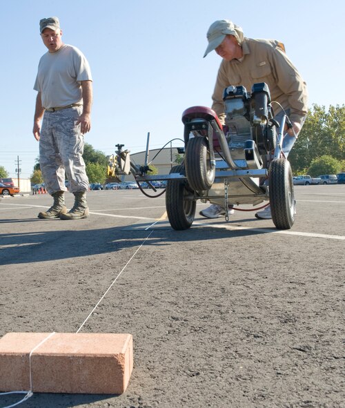 Master Sgt. Ernest Pope, 2nd Maintenance Squadron, and Keith Green, contracted motorcycle instructor, mark lines for a motorcycle range in a parking lot on Barksdale Air Force Base, La., Oct. 7. The motorcycle range will be used to teach the base motorcyclists proper riding techniques and allow riders to practice their skills. (U.S. Air Force photo/Airman 1st Class Benjamin Gonsier)(RELEASED)  