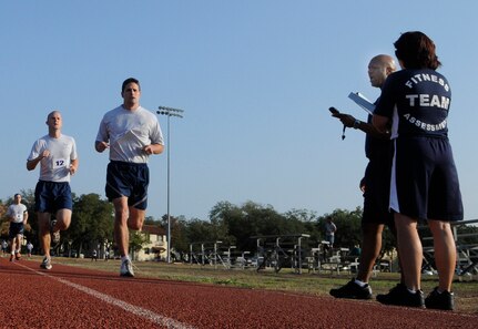 Ronnie King, 902nd Force Support Squadron Fitness Assessment Cell evaluator, clocks and provides running times to Randolph Air Force Base, Texas, military members as they complete their yearly fitness evaluation assessment. (U.S. Air Force Photo by Don Lindsey) 