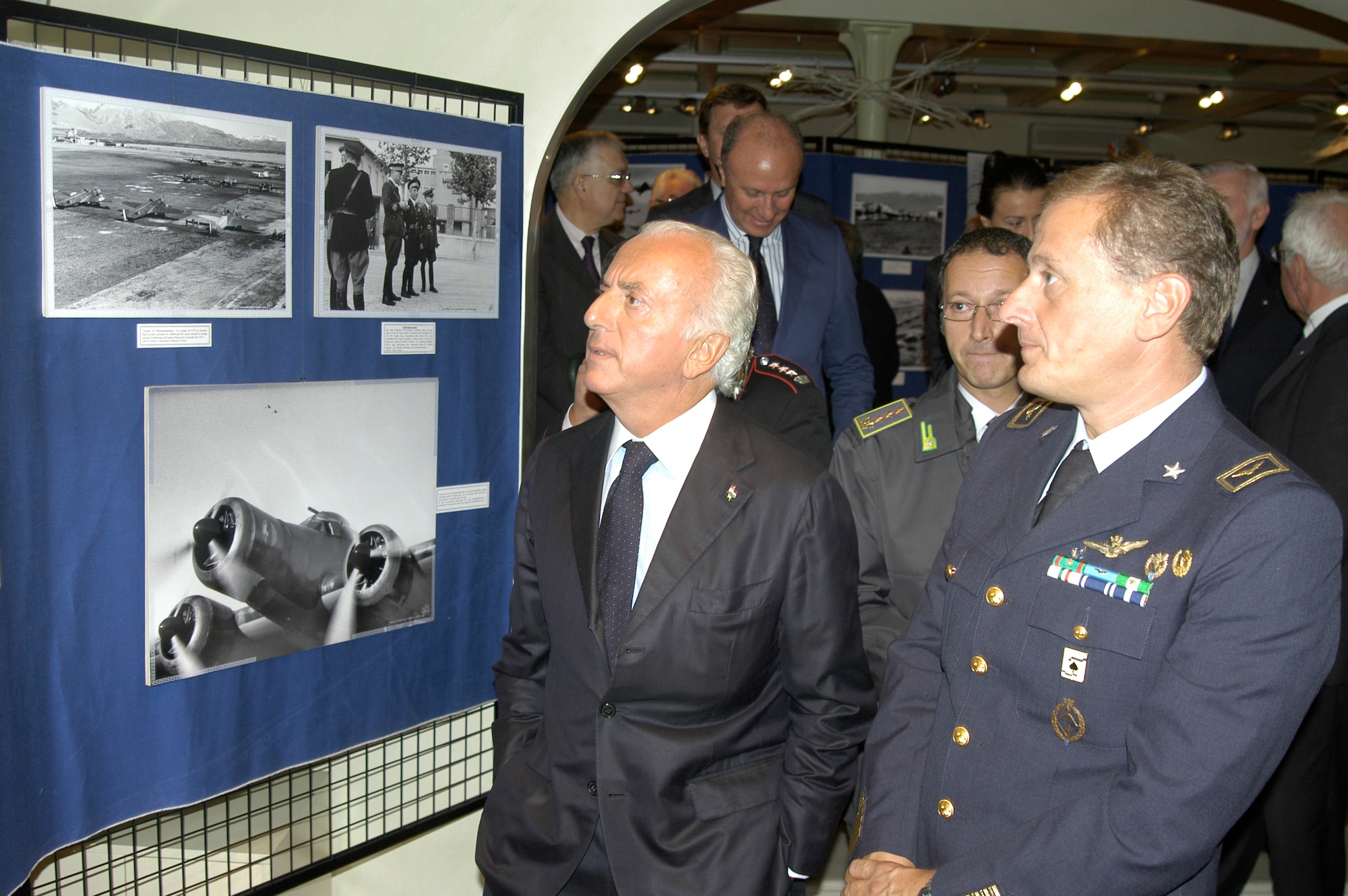 From left, the Prefect of Pordenone, Dr. Pierfrancesco Galante and Col. Luca Cappelli, commander of the “Pagliano e Gori” airport, look at a series of photos portraying the Aviano airport throughout the past 100 years. The photo exhibition is open through Oct. 23 and is located at Palazzo Gregoris in Pordenone, Italy. (Courtesy photo)