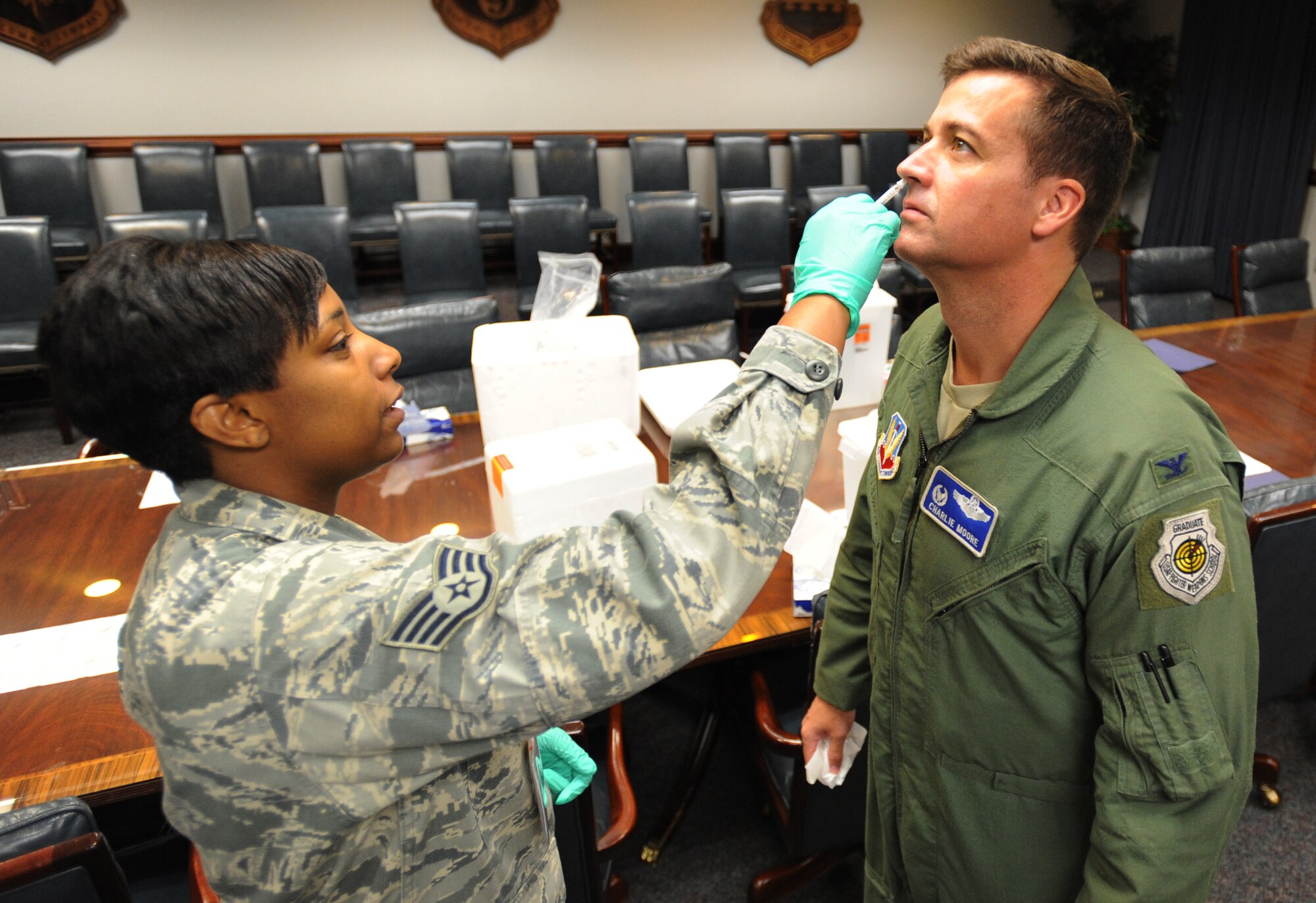 U.S. Air Force Staff Sgt. Tamesha Green, 20th Medical Group medical technician, administers Col. Charlie Moore, 20th Fighter Wing commander, the seasonal live Intranasal Vaccine, Shaw Air Force Base, S.C., Oct. 7, 2011. The vaccine is administered to prevent the flu and cold virus. (U.S. Air Force photo by Airman 1st Class Tabatha Duarte/Released)