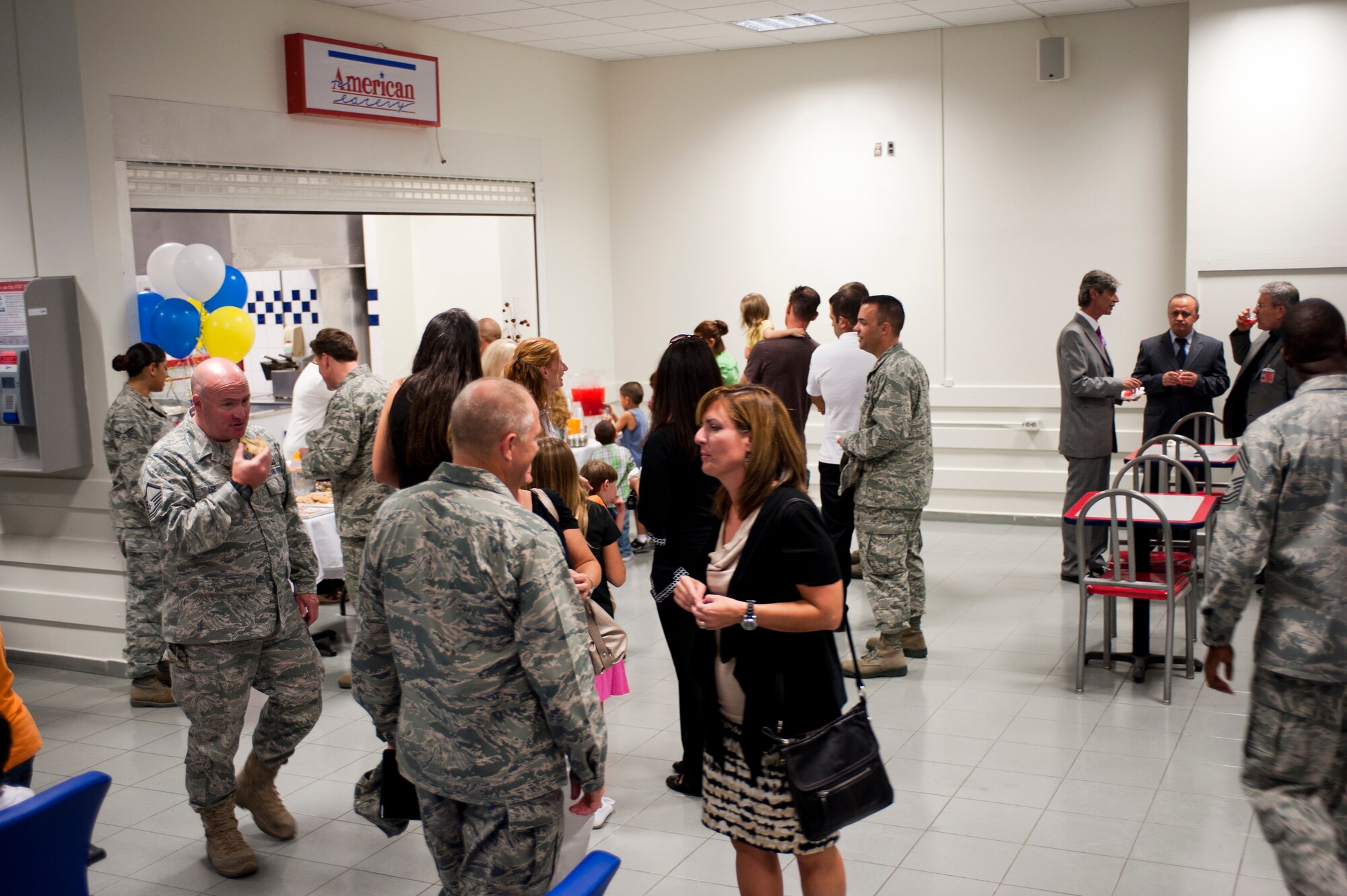 Airmen and their families partake in snacks and refreshments while touring the renovated Air Mobility Command Passenger Terminal Oct. 5, 2011, at Incirlik Air Base, Turkey. The improvements to the terminal include a new heating, ventilation and air conditioning system; a drop ceiling; improved lighting to increase interior luminosity; and updates to the family and special category lounges. The terminal was constructed in 1972, an automated conveyor belt was added in 1997 and an arrival terminal in 2004. (U.S. Air Force photo by Senior Airman Clayton Lenhardt/Released)