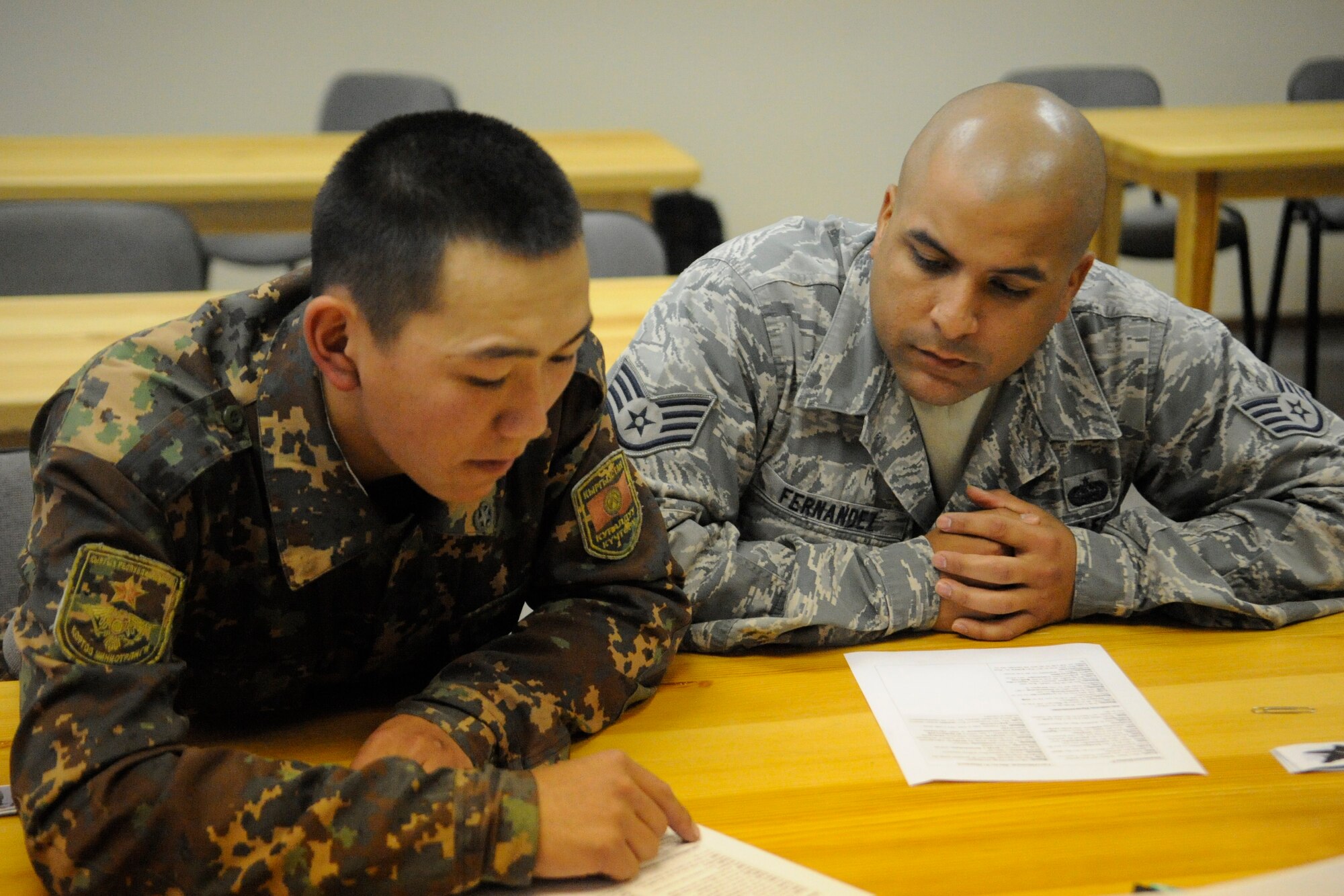 Staff Sgt. Jonathan Fernandez teaches proper enunciation to a private from the Koi Tash Noncommissioned Officers Academy, Kyrgyzstan, during a language lab Oct. 6. Fernandez is assigned to the Theater Security Cooperation as the NCO-in-charge of knowledge operations. He is deployed to the Transit Center at Manas from Aviano Air Base, Italy. (U.S. Air Force photo/Tech. Sgt. Tammie Moore)