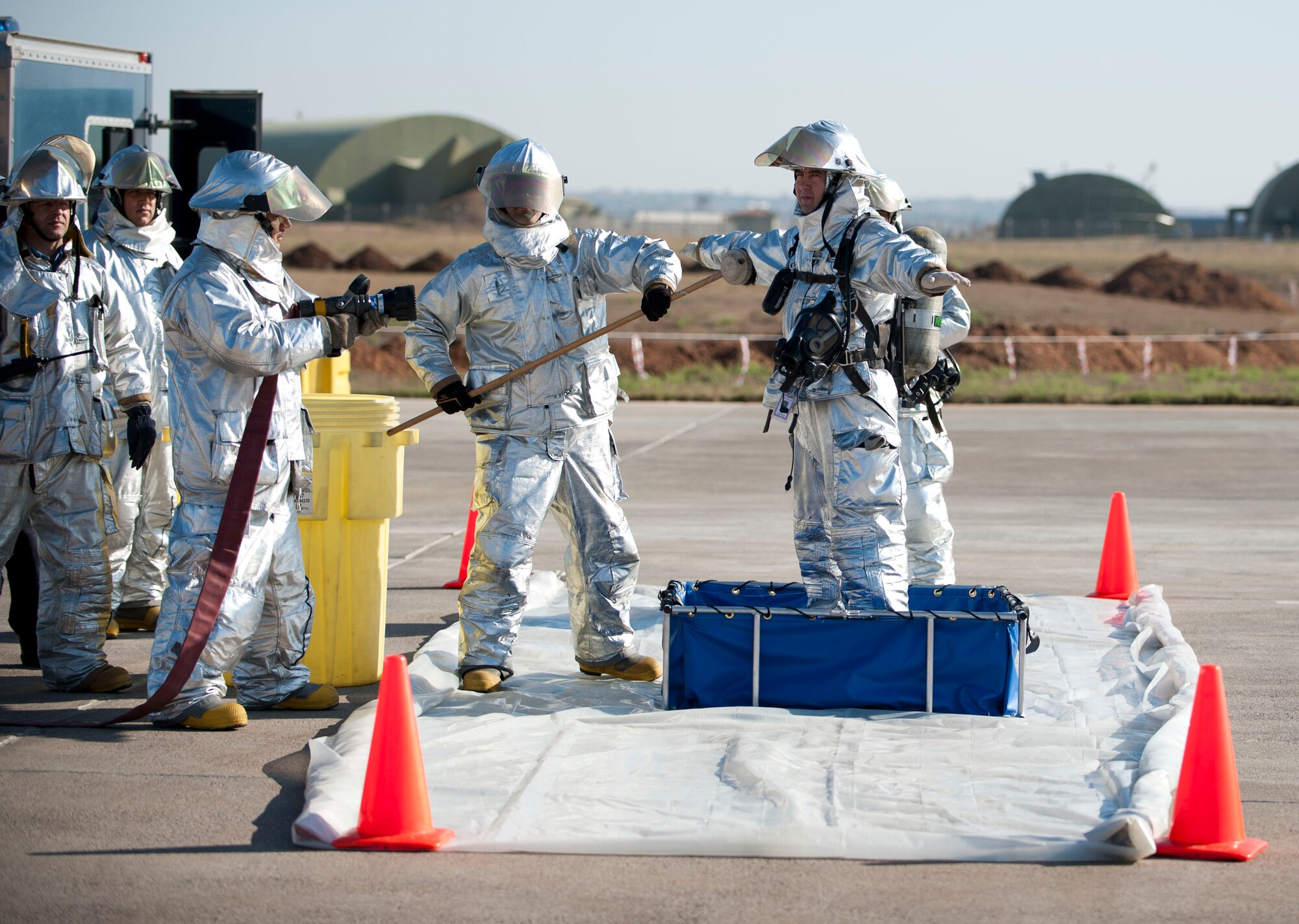 Firefighters simulate being decontaminated after leaving a simulated fuel spill during a fuel spill response exercise Oct. 5, 2011, at Incirlik Air Base, Turkey. The firefighters would decontaminate to keep themselves from spreading hazardous material. (U.S. Air Force photo by Senior Airman Clayton Lenhardt/Released)