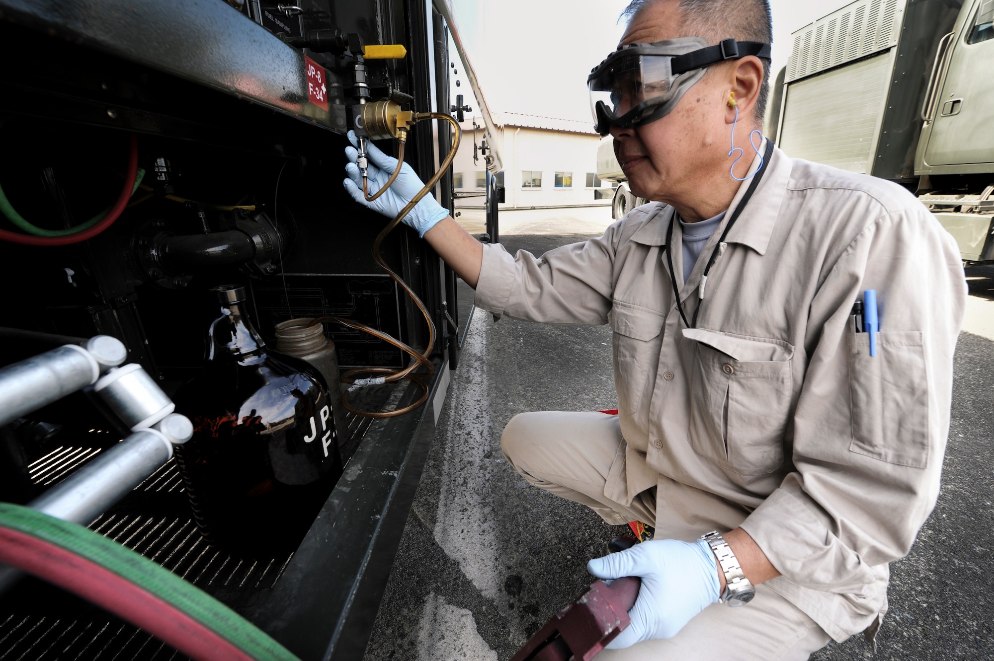 YOKOTA AIR BASE, Japan --Susumu Iwasaki, 374th Logistics Readiness Squadron fuels laboratory technician, runs a monthly quality assurance test on an R-11 6,000-gallon JP8 refueling truck at Yokota Air Base, Japan, Sept. 28, 2011. Tests are completed to check for proper operation of R-11 filter separator, the final filtration point before fuel reaches an aircraft. (U.S. Air Force photo/Staff Sgt Stacy Moless)