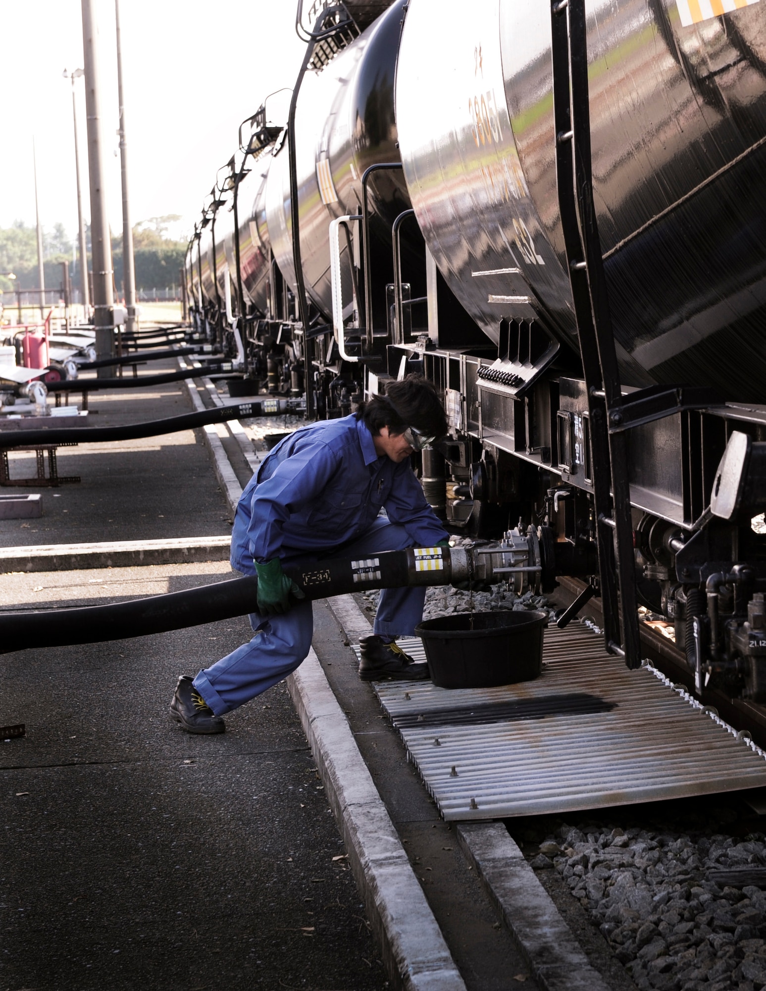 YOKOTA AIR BASE, Japan -- Hiroyuki Sekimoto, 374th Logistics Readiness Squadron fuels distribution system operator, connects a hose to an 11,900-gallon rail car at Yokota Air Base, Japan, Sept. 28, 2011. Hiroyuki connects the hose to an off-loading header that will hold 154,700-gallons of JP8 aviation turbine fuel. (U.S. Air Force photo/Staff Sgt Stacy Moless)