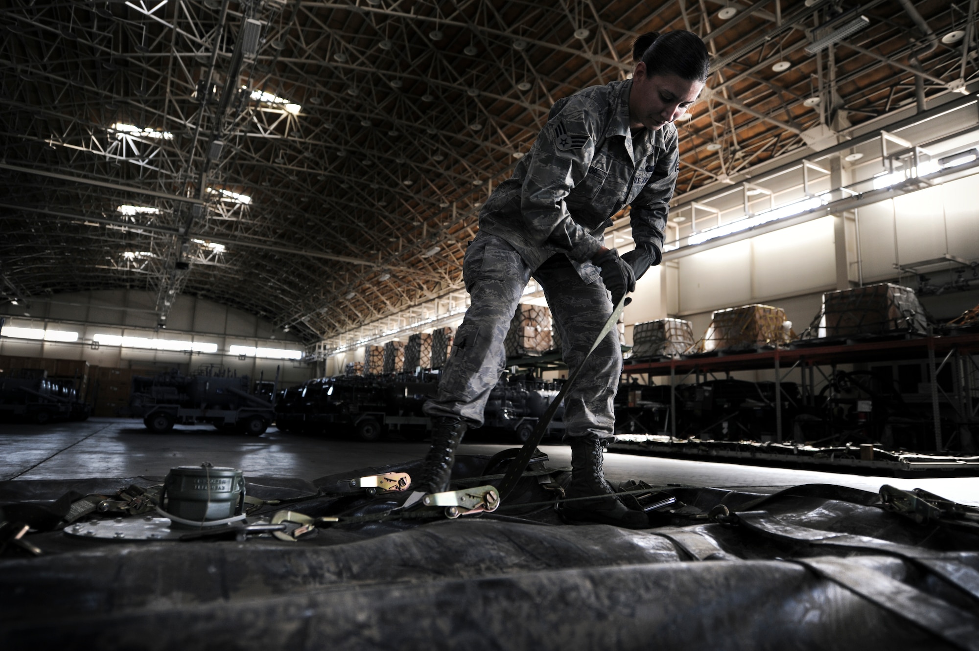 YOKOTA AIR BASE, Japan -- Senior Airman Sarah Bishop, 374th Logistics Readiness Squadron fuels mobility support operator, palletizes a 3,000-gallon bladder for an aerial bulk fuel delivery system kit, at Yokota Air Base, Japan, Sept. 28, 2011. Bishop took the bladder off to conduct an annual required inspection, then strapped it back onto the pallet for transport. (U.S. Photo/Staff Sgt Stacy Moless)   