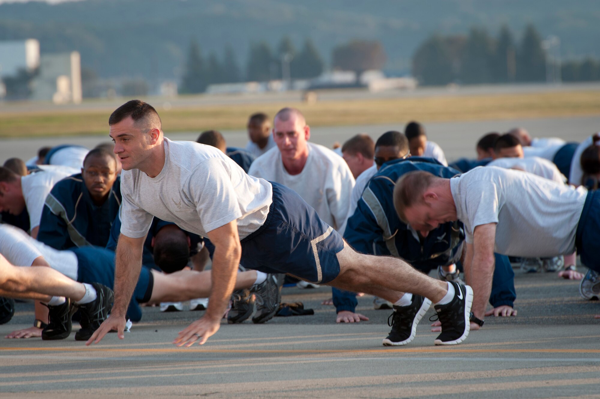 YOKOTA AIR BASE, Japan -- Master Sgt. Paul Stansbury, 374th Logistics Readiness Squadron first sergeant, lifts off the ground durning a pushup at Yokota Air Base, Japan, Oct. 7, 2011. During the first Friday of each month, the 374th Airlift Wing meets for the wing run to build esprit de corps and get fit. (U.S. Air Force photo/Staff Sgt. Samuel Morse)