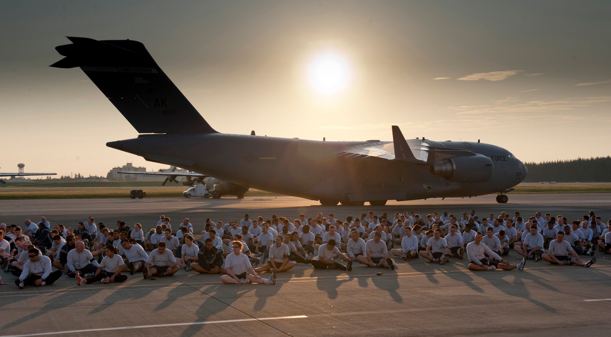 YOKOTA AIR BASE, Japan -- A C-17 Globemaster III cargo jet taxis by as Airmen from the 374th Airlift Wing stretch for the wing run at Yokota Air Base, Japan, Oct. 7, 2011. (U.S. Air Force photo/Staff Sgt. Samuel Morse)