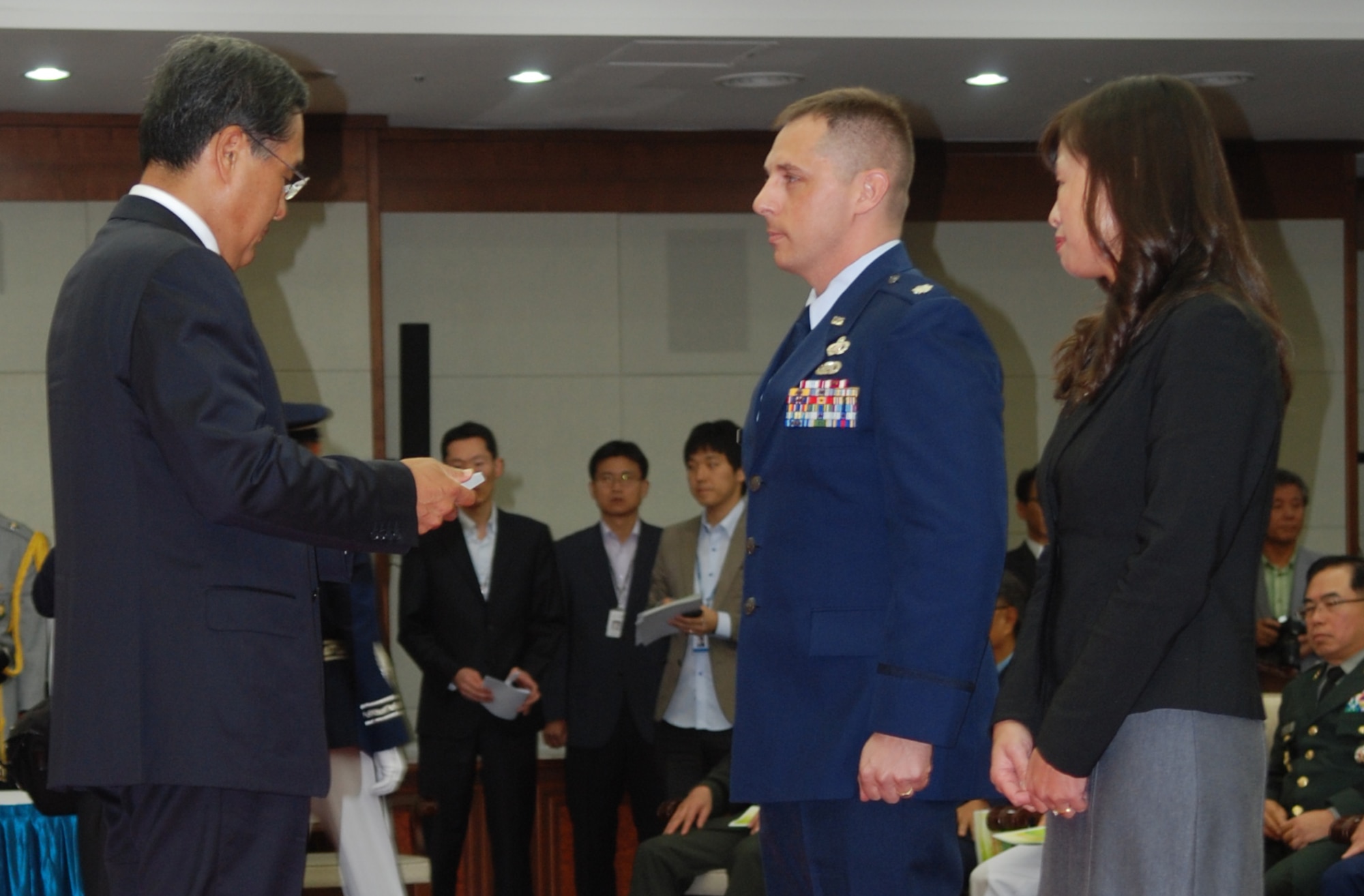 Mrs. Jennifer Maskery, wife of Lt. Col. Scott Maskery, watches on as her husband is presented the 2011 Patriot Award by Mr. Bang Sang-Hoon, Chosun Daily President. Lt. Col. Maskery was presented the award Sept. 30 for outstanding contributions to teh Republic of Korea (ROK)-US alliance. The ceremony, held at the ROK Ministry of National Defense compound, marks only the second ROK-US Alliance Award given, and teh first time it has been awarded to an Airman. (U.S. Air Force photo by Maj Eric Badger)