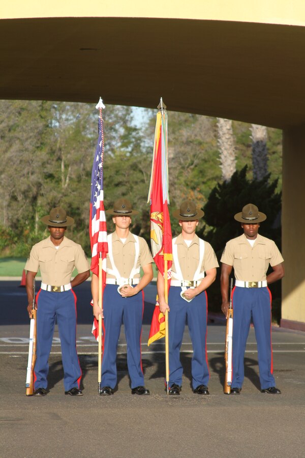 A Marine color guard stands at parade rest before marching on the colors for the morning colors ceremony Oct. 7. This color guard is comprised of drill instructors from Marine Corps Recruit Depot San Diego. They carry the national ensign and the battle standard of the Marine Corps out to the ceremony while the national anthem is played.