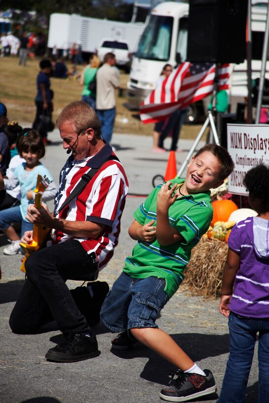 James Bagley, 8, rocks out on his air guitar with Rick Hubbard during the Kazoobie Kazoo show at the Mumfest in New Bern, N.C., Oct. 8. Hubbard performs his Kazoobie Kazoo show and an original "Who can do it? I  Can!" show for festivals and elementary schools across the U.S. At each performance, Hubbard prides himself in getting all audience members involved, especially the children who get the chance to sing, dance, play maracas and even play a kazoo given to them by Hubbard in a kazoo finale.