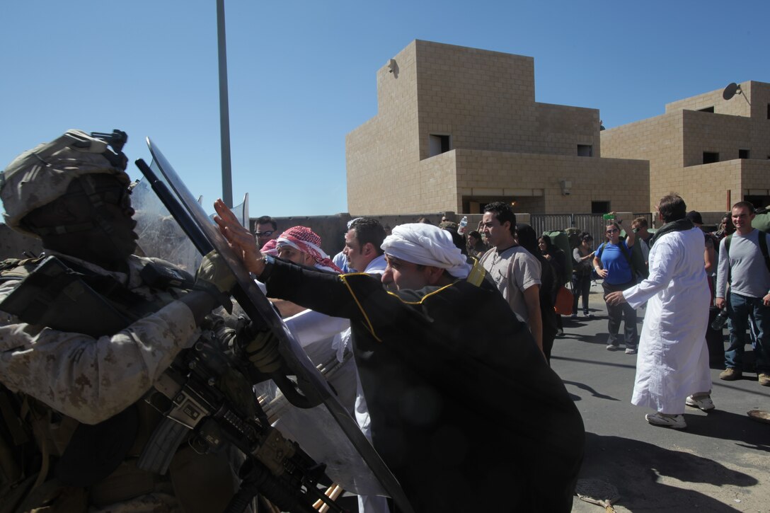 Marines and sailors with the 11th Marine Expeditionary Unit control a rowdy crowd here Oct. 8 during a noncombatant evacuation exercise. The unit embarked USS Makin Island, USS New Orleans and USS Pearl Harbor in San Diego Sept. 28 and is participating in its final exercise before deploying in November.