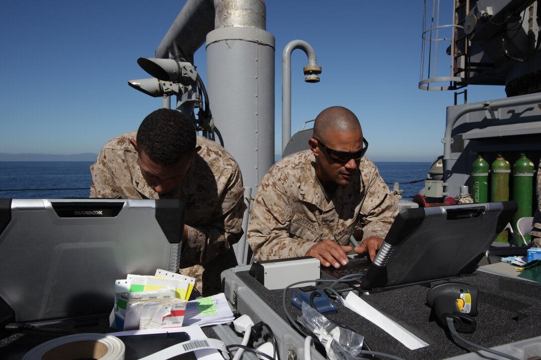 Lance Cpl. Joen P. Dyal, left, and Lance Cpl. Caylen S. Vetter use a noncombatant tracking system to process evacuees aboard USS Pearl Harbor here Oct. 8 during an exercise. Dyal and Vetter are landing support specialists with Combat Logistics Battalion 11, 11th Marine Expeditionary Unit. The unit embarked USS Makin Island, USS New Orleans and USS Pearl Harbor in San Diego Sept. 28 and is participating in its final exercise before deploying in November. Dyal, 21, hails from Sacramento, Calif. Vetter, 24, hails from Bishop, Calif.