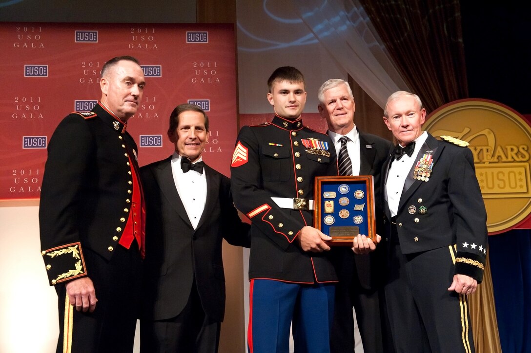 Marine Corps Sgt. Lucas Chaffins receives the USO Marine of the Year Award from Marine Corps Gen. Joseph F. Dunford Jr., assistant commandant of the Marine Corps; USO President Sloan D. Gibson; retired Air Force Gen. Richard B. Myers, former chairman of the Joint Chiefs of Staff; and Army Gen. Martin E. Dempsey, chairman of the Joint Chiefs of Staff, during the 2011 USO Gala in Washington, D.C., Oct. 6, 2011.