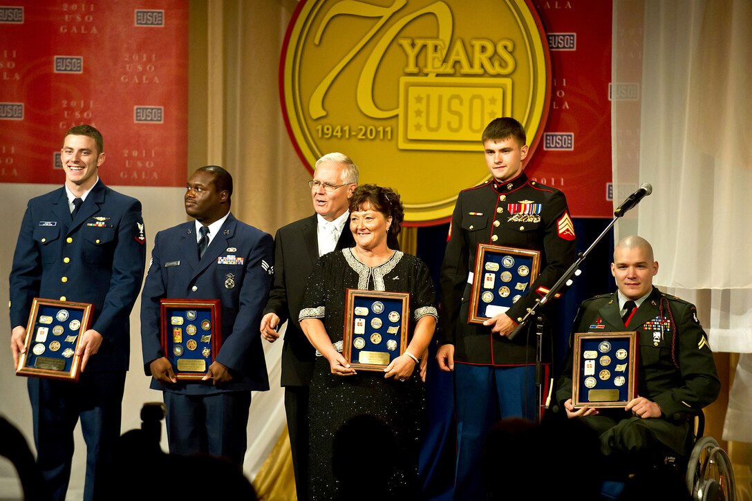 From left to right: Coast Guard Petty Officer 3rd Class Christopher Austin; Air Force Senior Airman James Baynard; Scott and Shirene Regelin, the parents of Petty Officer 1st Class Chad R. Regelin; Marine Sgt. Lucas Chaffins; and Army Cpl. David Bixler receive awards after being named USO Service Members of the Year during the 2011 USO Gala in Washington, D.C., Oct. 6, 2011.