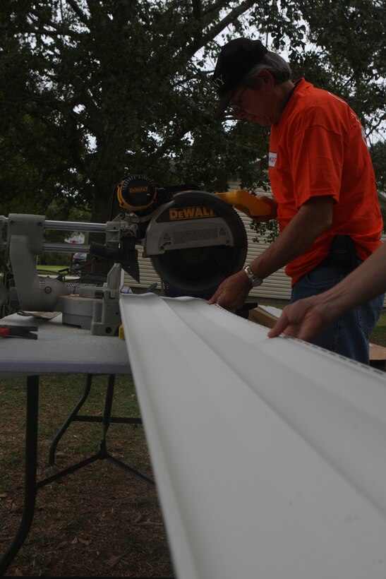 Volunteers cut vinyl siding for the side of Eric and Cheryl LeClair’s house during the Military Missions In Action build in Swansboro, N.C., Oct. 10. The LeClair’s house, in serious need of repair, was refurbished by volunteers from MMIA, Home Depot and Wellness for Warriors.