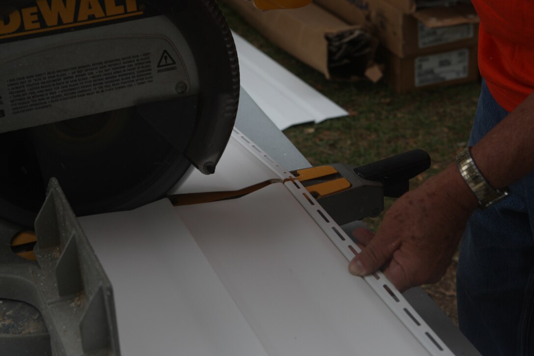 Volunteers cut vinyl siding for the side of Eric and Cheryl LeClair’s house during the Military Missions In Action build in Swansboro, N.C., Oct. 10. The LeClair’s house, in serious need of repair, was refurbished by volunteers from MMIA, Home Depot and Wellness for Warriors.