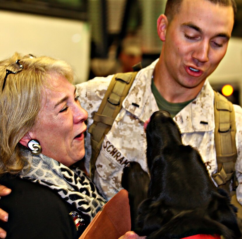 1st Lt. Benjamin T. Schramm, a platoon commander with 2nd Maintenance Battalion, 2nd Marine Logistics Group, gets a loving kiss from his dog during a homecoming ceremony Oct. 14, 2011, aboard Marine Corps Base Camp Lejeune, N.C. Family members, friends, Marines and sailors recently gathered for the event to welcome the unit back from their six-month tour in Helmand Province, Afghanistan. (Photo by Cpl. Andrew D. Johnston)