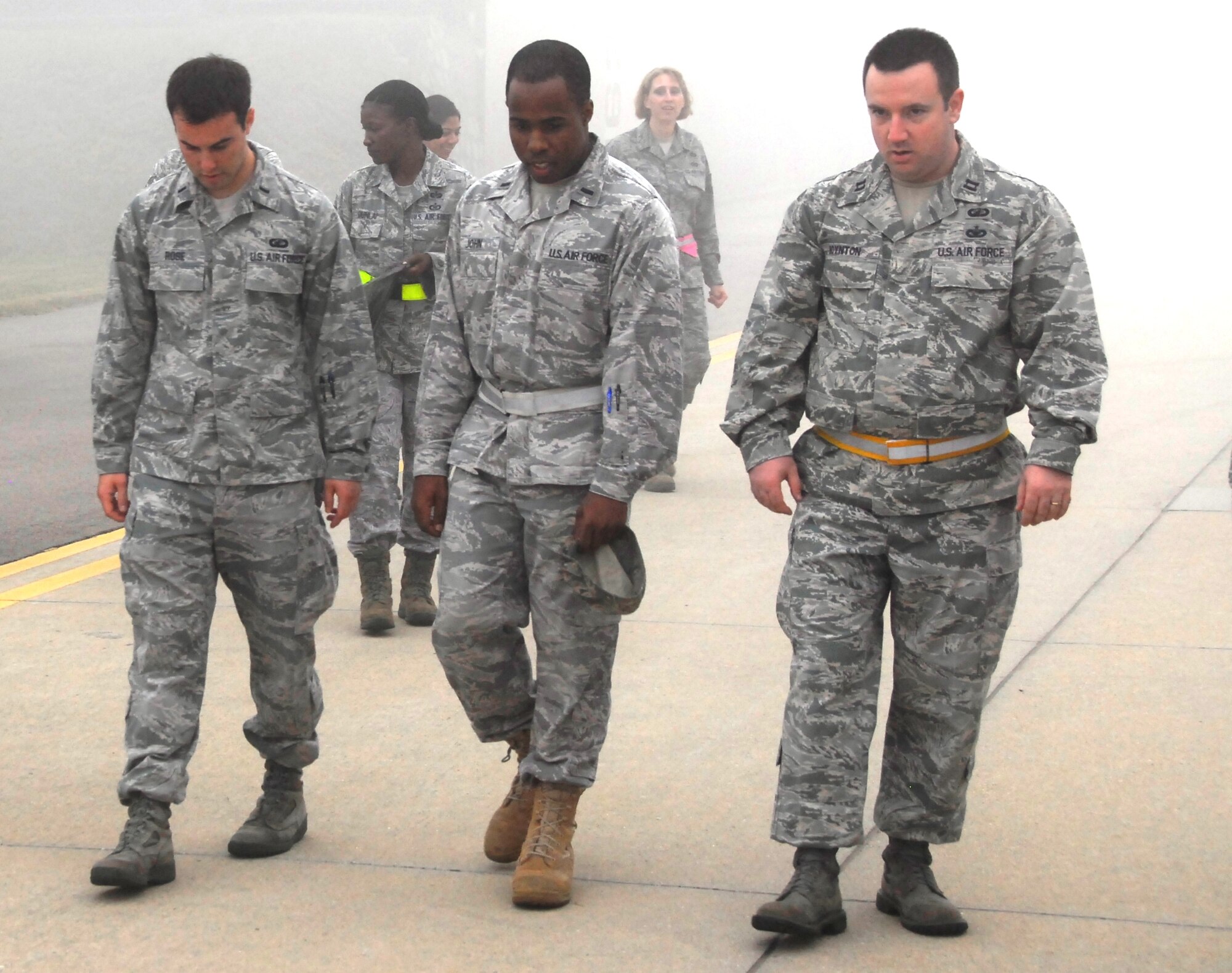 First Lt. David Rose, 51st Fighter Wing Plans, 1st Lt. Edward John and Capt. Christopher Boynton, both assigned to the 51st Comptroller Squadron, search Oct. 11, 2011, for foreign objects and potentially damaging debris on a taxiway along with other Airmen of the wing staff agencies. A wing-wide FOD walk was conducted following construction on the Osan Air Base airfield. (Air Force Photo by Senior Master Sgt. Stuart Camp)