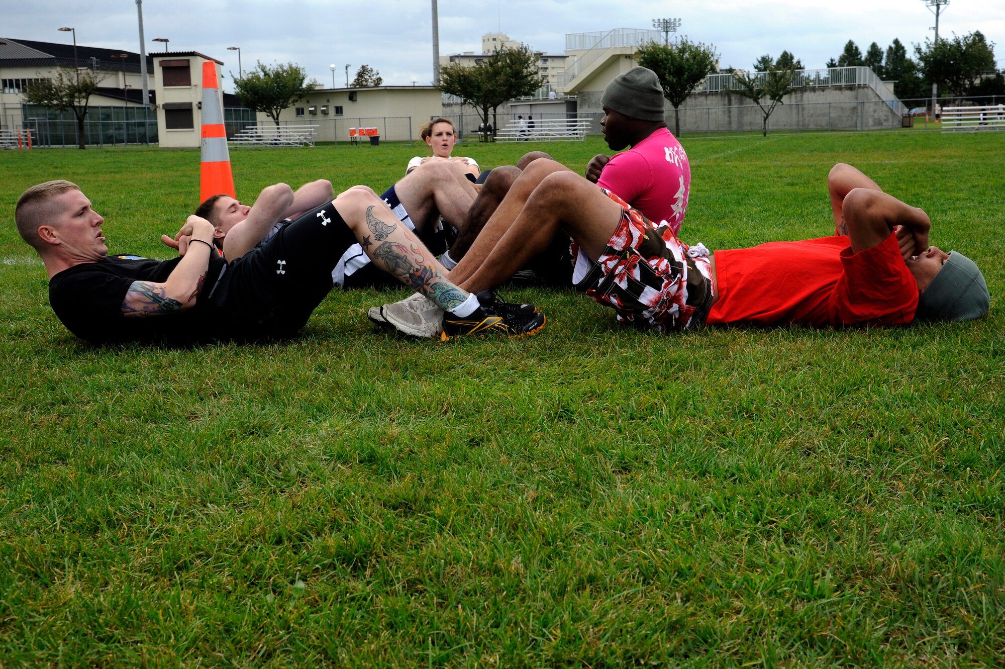 MISAWA AIR BASE, Japan - Members of the 35th Logistics Readiness Squadron perform synchronized sit-ups in the readiness competition during the wing sports day here Oct. 7. The 35th Fighter Wing held a sports day to promote physical fitness, teamwork, competition, sportsmanship and esprit de corps. The day was kicked off with a 3-mile run followed by various sporting events to include relay races, basketball, softball, ultimate frisbee, soccer and a readiness competition. Approximately 14 units from the base formed teams to participate in each event. (U.S. Air Force photo/Tech. Sgt. Marie Brown)