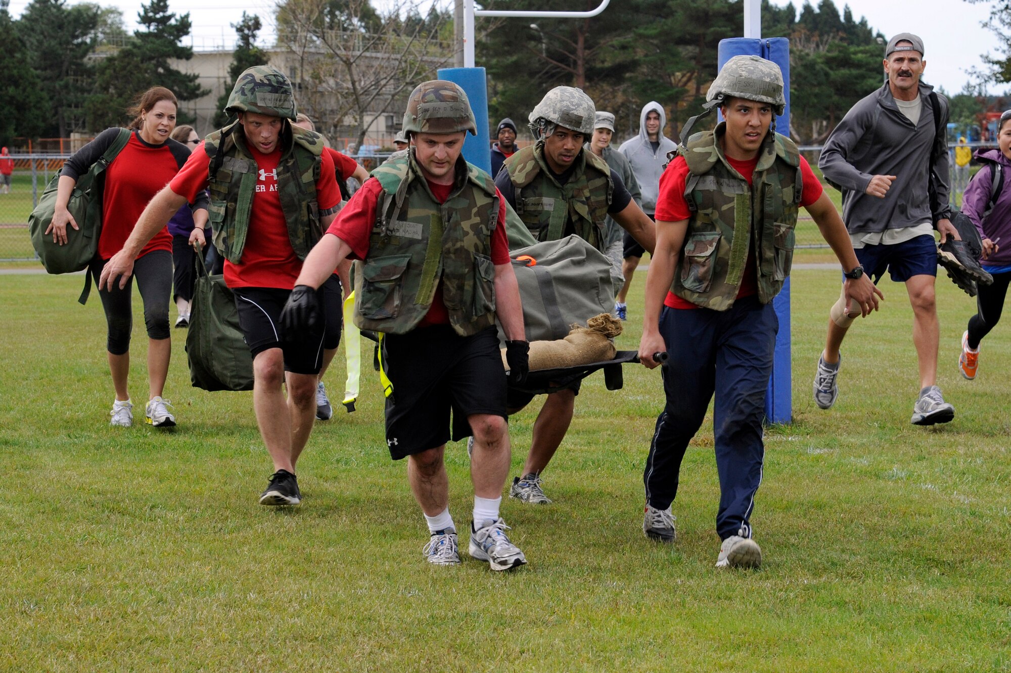 MISAWA AIR BASE, Japan - Members of the 35th Medical Group carry a litter with chemical gear and sand bags to the finish line in the readiness competition during the wing sports day here Oct. 7. The 35th Fighter Wing held a sports day to promote physical fitness, teamwork, competition, sportsmanship and esprit de corps. The day was kicked off with a 3-mile run followed by various sporting events to include relay races, basketball, softball, ultimate frisbee, soccer and a readiness competition. Approximately 14 units from the base formed teams to participate in each event. (U.S. Air Force photo/Tech. Sgt. Marie Brown)