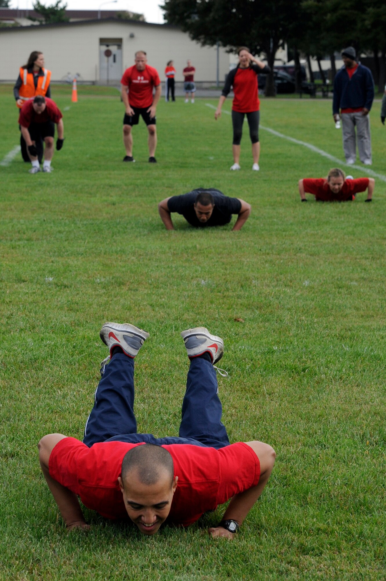 MISAWA AIR BASE, Japan - Members of the 35th Medical Group perform burpee exercises in the readiness competition during the wing sports day here Oct. 7. The 35th Fighter Wing held a sports day to promote physical fitness, teamwork, competition, sportsmanship and esprit de corps. The day was kicked off with a 3-mile run followed by various sporting events to include relay races, basketball, softball, ultimate frisbee, soccer and a readiness competition. Approximately 14 units from the base formed teams to participate in each event. (U.S. Air Force photo/Tech. Sgt. Marie Brown)