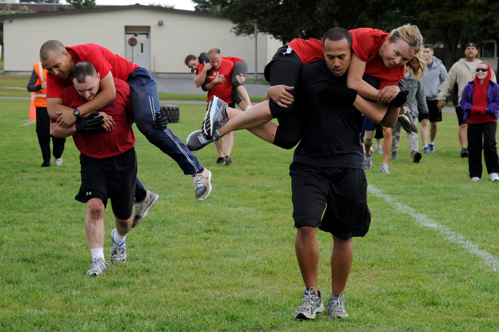 MISAWA AIR BASE, Japan - Members of the 35th Medical Group fireman carry their partner in the readiness competition during the wing sports day here Oct. 7. The 35th Fighter Wing held a sports day to promote physical fitness, teamwork, competition, sportsmanship and esprit de corps. The day was kicked off with a 3-mile run followed by various sporting events to include relay races, basketball, softball, ultimate frisbee, soccer and a readiness competition. Approximately 14 units from the base formed teams to participate in each event. (U.S. Air Force photo/Tech. Sgt. Marie Brown)