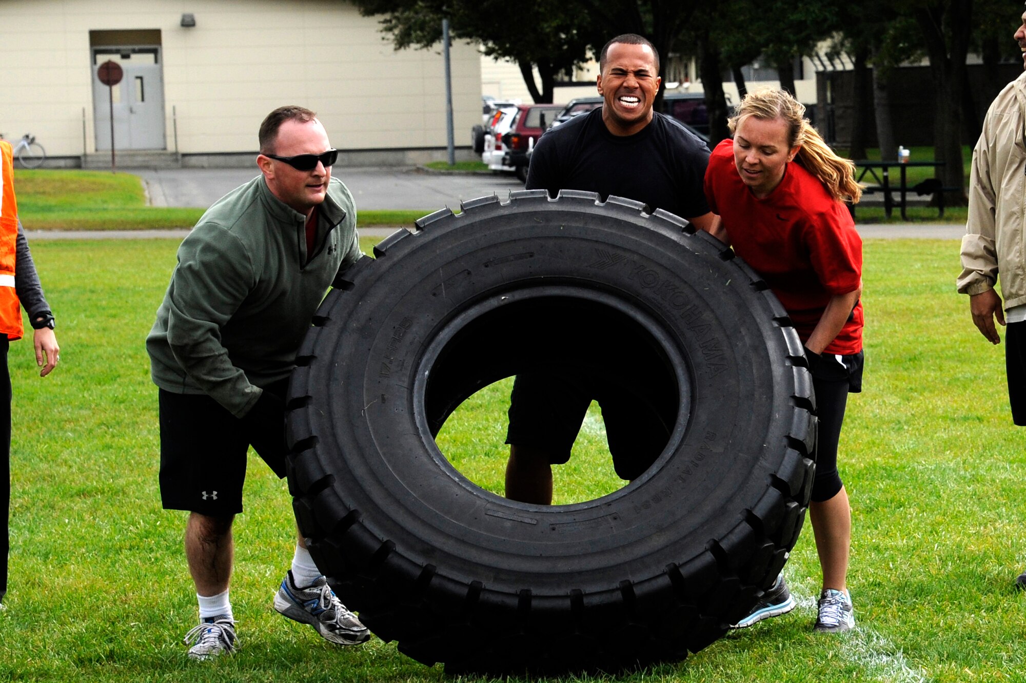MISAWA AIR BASE, Japan - Members of the 35th Medical Group flip a tire in the readiness competition during the wing sports day here Oct. 7. The 35th Fighter Wing held a sports day to promote physical fitness, teamwork, competition, sportsmanship and esprit de corps. The day was kicked off with a 3-mile run followed by various sporting events to include relay races, basketball, softball, ultimate frisbee, soccer and a readiness competition. Approximately 14 units from the base formed teams to participate in each event. (U.S. Air Force photo/Tech. Sgt. Marie Brown)