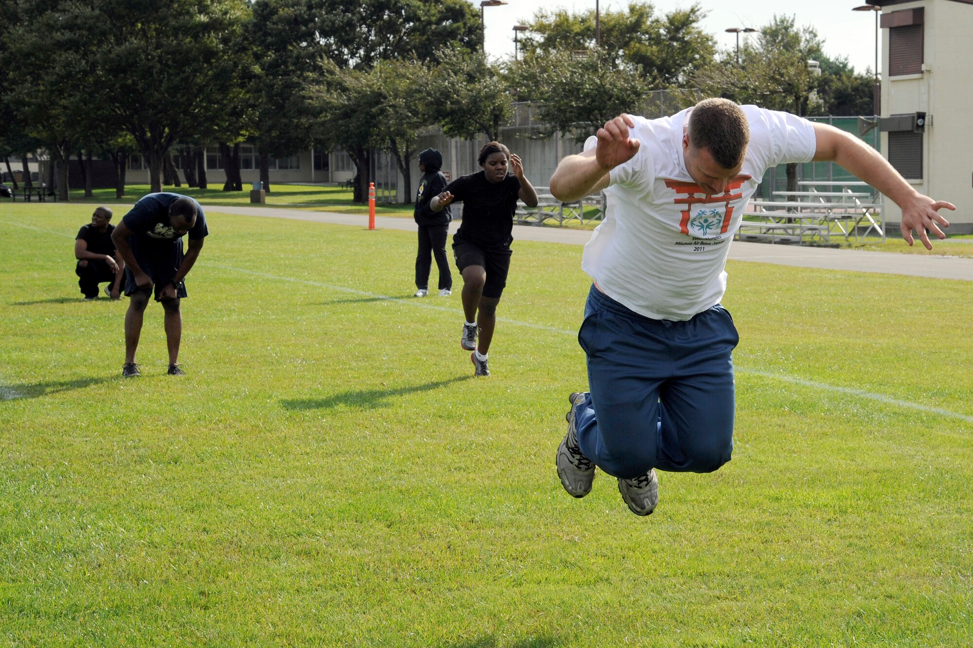 MISAWA AIR BASE, Japan - Members of the 35th Security Forces Squadron perform burpee exercises in the readiness competition during the wing sports day here Oct. 7.  The 35th Fighter Wing held a sports day to promote physical fitness, teamwork, competition, sportsmanship and esprit de corps. The day was kicked off with a 3-mile run followed by various sporting events to include relay races, basketball, softball, ultimate frisbee, soccer and a readiness competition. Approximately 14 units from the base formed teams to participate in each event. (U.S. Air Force photo/Tech. Sgt. Marie Brown)