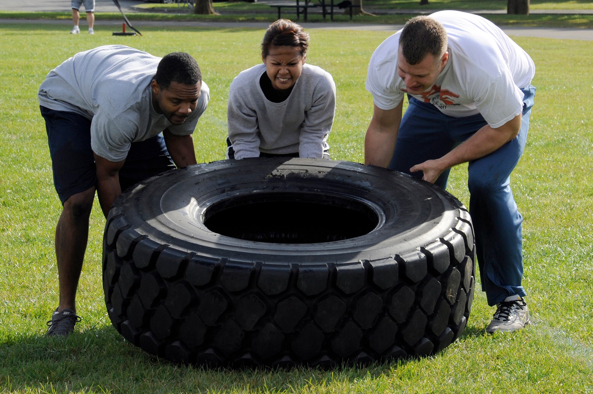 MISAWA AIR BASE, Japan - Members of the 35th Security Forces Squadron flip a tire in the readiness competition during the wing sports day here Oct. 7. The 35th Fighter Wing held a sports day to promote physical fitness, teamwork, competition, sportsmanship and esprit de corps. The day was kicked off with a 3-mile run followed by various sporting events to include relay races, basketball, softball, ultimate frisbee, soccer and a readiness competition. Approximately 14 units from the base formed teams to participate in each event. (U.S. Air Force photo/Tech. Sgt. Marie Brown)