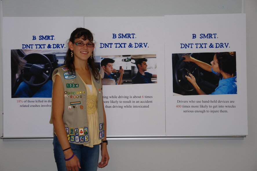 Amber Wolfe stands by the posters she created for a community awareness campaign about the dangers of texting while driving as part of her Girl Scout Gold Award project. Amber is the daughter of Shawn and Dee Wolfe, both of whom are AEDC employees. (Photo by Andrea Stephens)