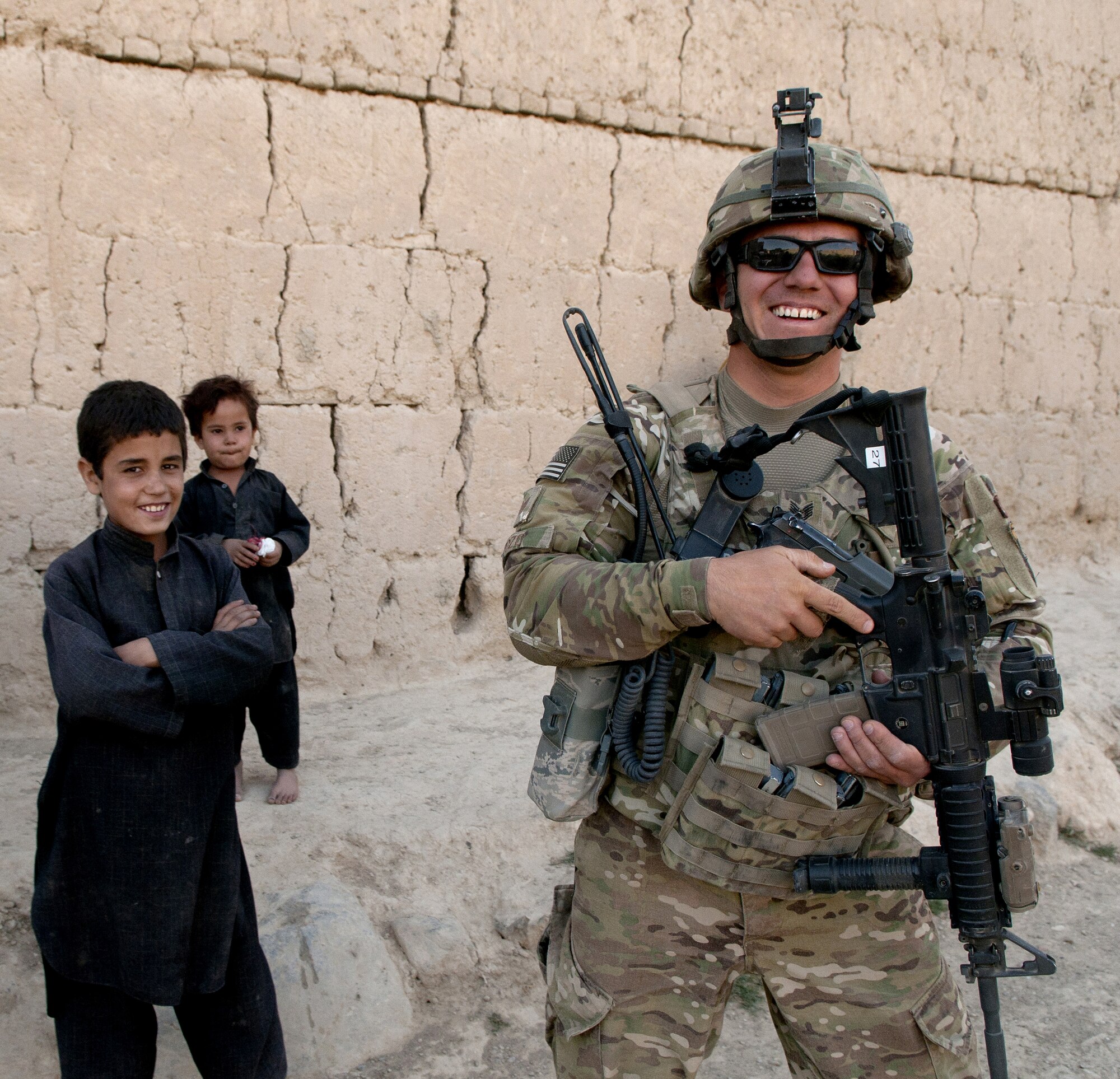 BAGRAM AIRFIELD, Afghanistan -- Tech. Sgt. Luis Pozo, 455th Expeditionary Security Forces Squadron Quick Response Team patrol leader poses with a local child during a dismounted patrol outside the wire Sept. 26, 2011. Pozo is deployed from Illinois Air National Guard, and is a native of Chicago, Ill. (U.S. Air Force photo/Senior Airman Krista Rose)