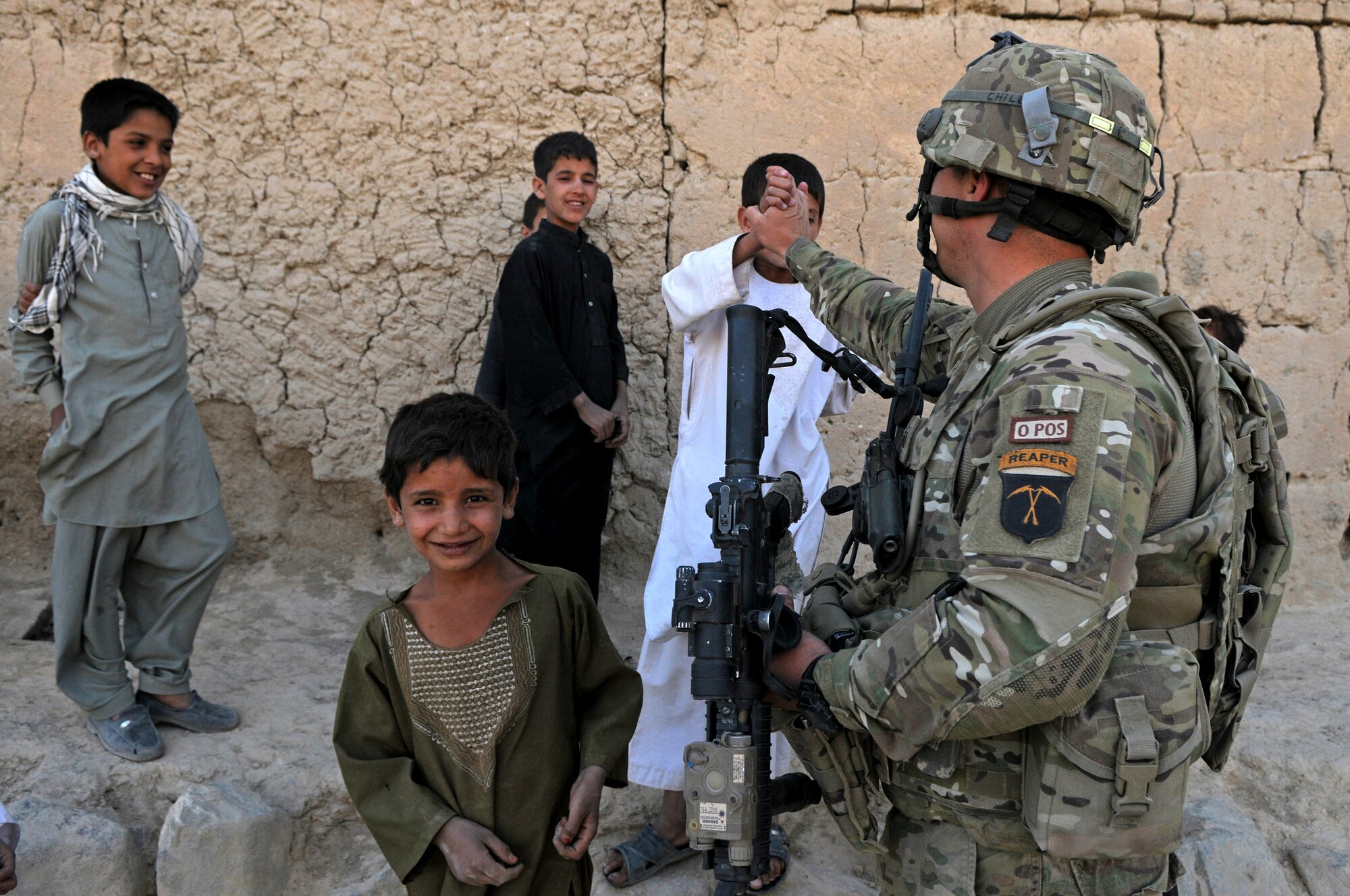 BAGRAM AIRFIELD, Afghanistan -- Tech. Sgt. Luis Pozo, 455th Expeditionary Security Forces Squadron Quick Response Team patrol leader gives a local child a high five during a dismounted patrol outside the wire Sept. 26, 2011. Pozo is deployed from Illinois Air National Guard, and is a native of Chicago, Ill. (U.S. Air Force photo/Senior Airman Krista Rose)