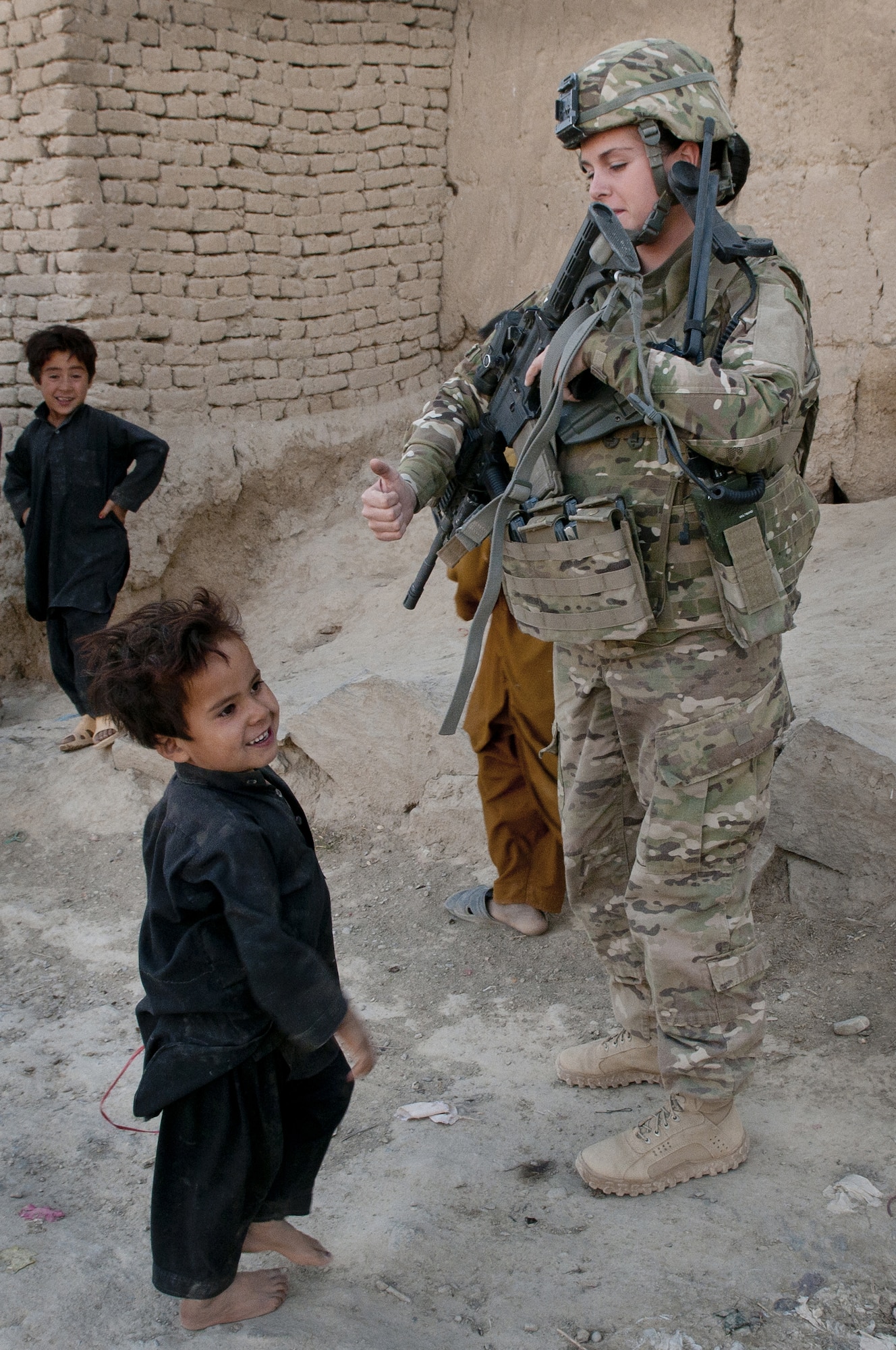 BAGRAM AIRFIELD, Afghanistan -- Senior Airman Courtney Folley, 455th Expeditionary Security Forces Squadron Quick Response Team radio telephone operator, gives thumbs up to a local child while conducting a dismounted patrol outside the wire Sept. 26, 2011. Folley is deployed from Rhode Island Air National Guard. (U.S. Air Force photo/Senior Airman Krista Rose)